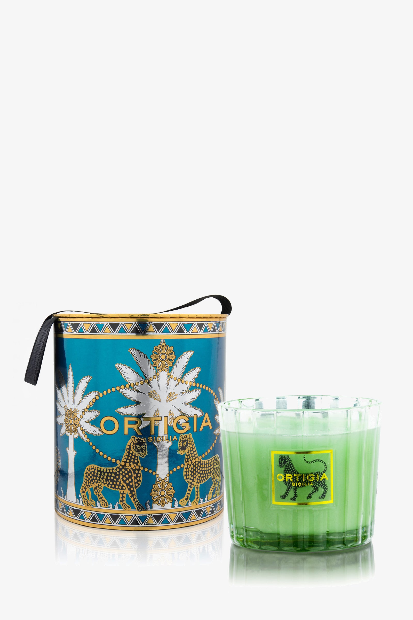 A blue Ortigia Fico D'India 4 Wick Candle box with palm tree and leopard designs sits beside a green glass candle, both adorned with black leopard motifs and Ortigia labels.