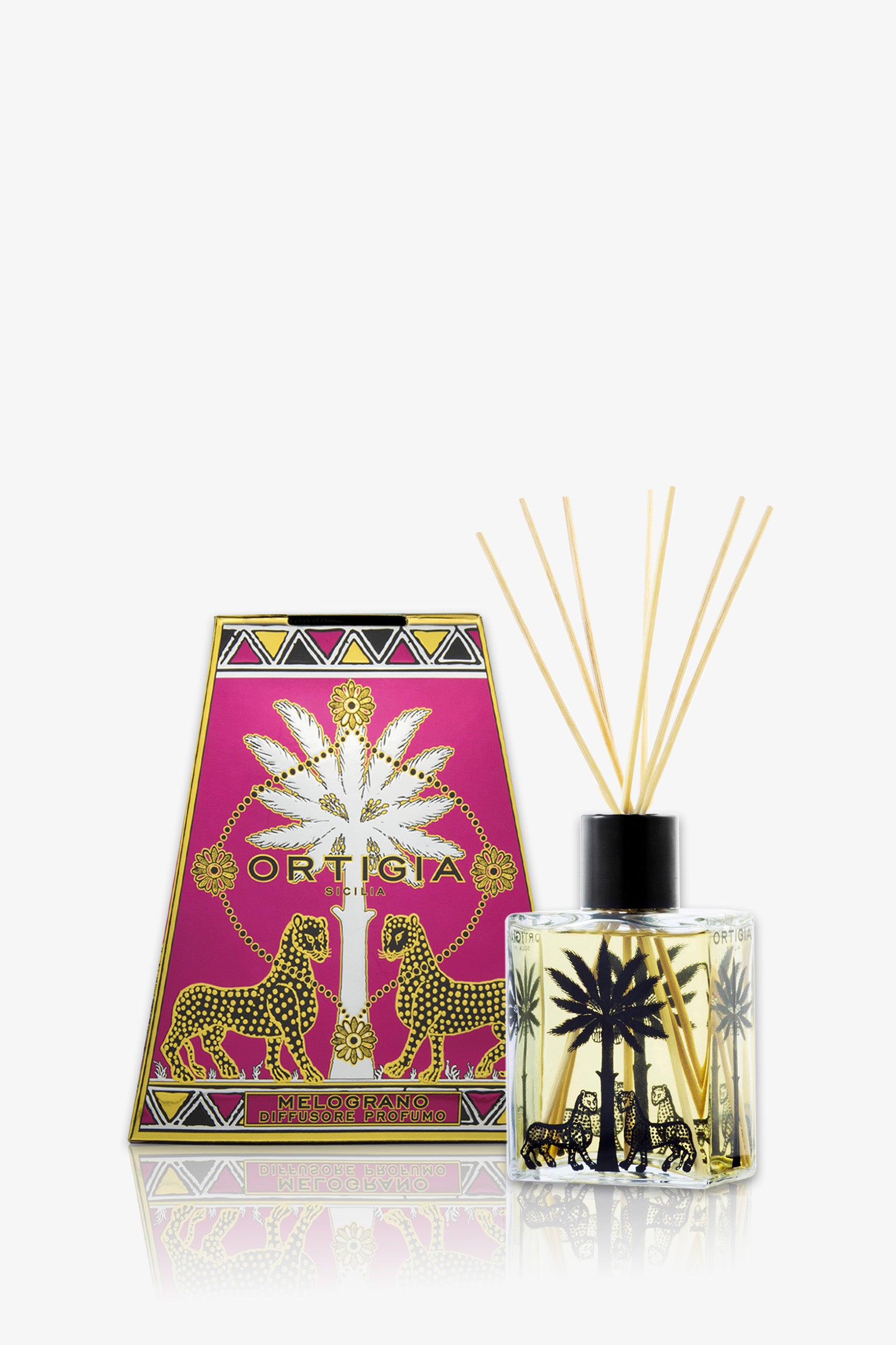 The Ortigia Melograno Diffuser features golden reeds in a red square glass bottle adorned with black palm tree and leopard designs, presented alongside a vibrant matching box.