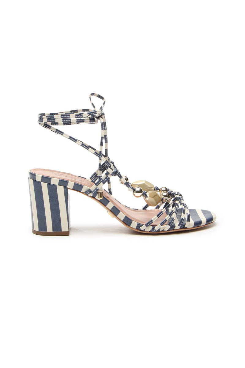 The Mantua Block Heel Sandal in BLUE features navy and white vertical stripes, a chunky block heel, ankle wrap straps, and decorative front beads.