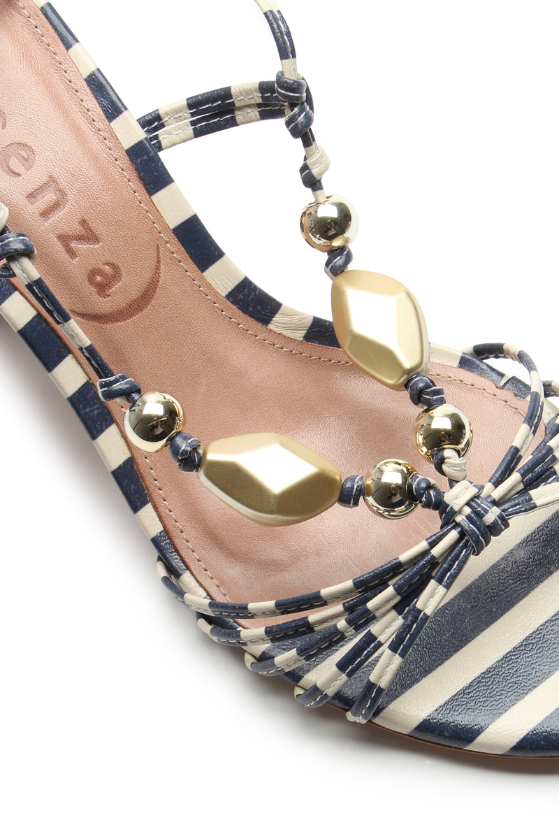 Close-up of the Mantua Block Heel Sandal featuring navy blue and white stripes, gold and metallic bead accents, and a tan insole with a partially visible brand name.