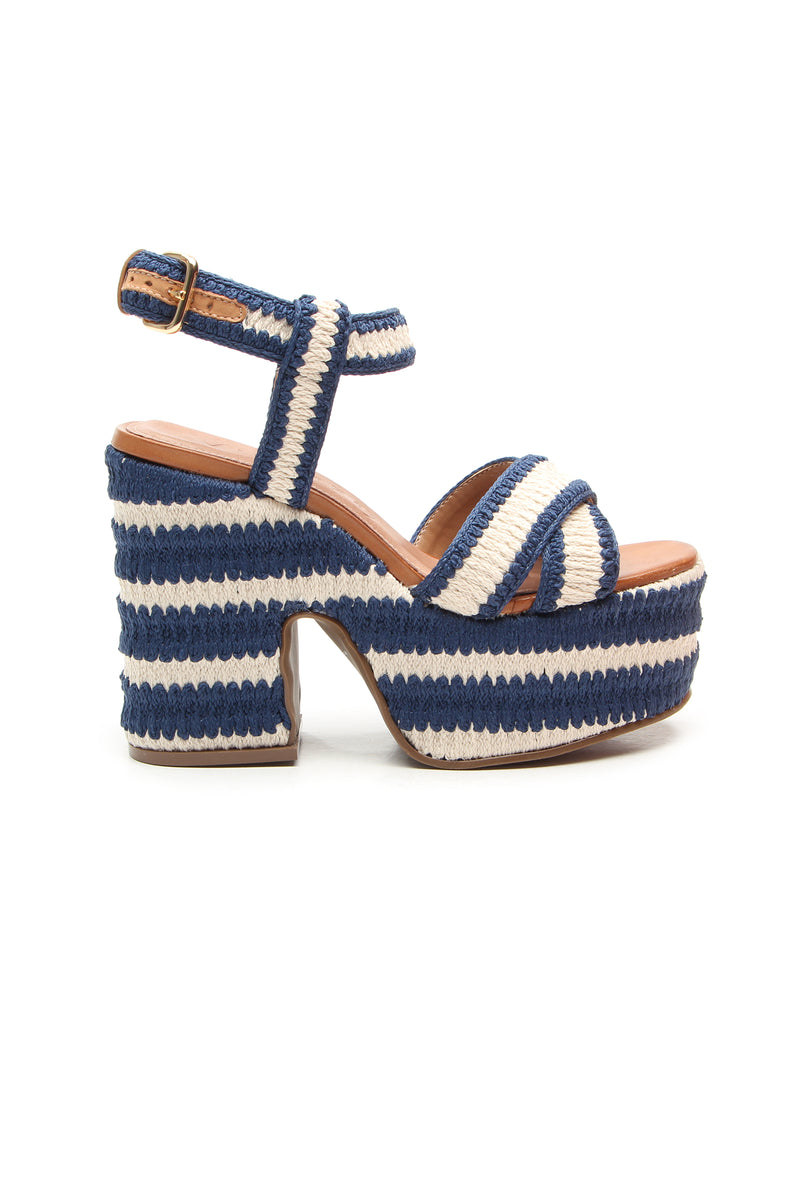The Zamzibar Platform is a navy sandal with a chunky heel, blue and white striped woven material, cross-toe straps, and an ankle strap with buckle.