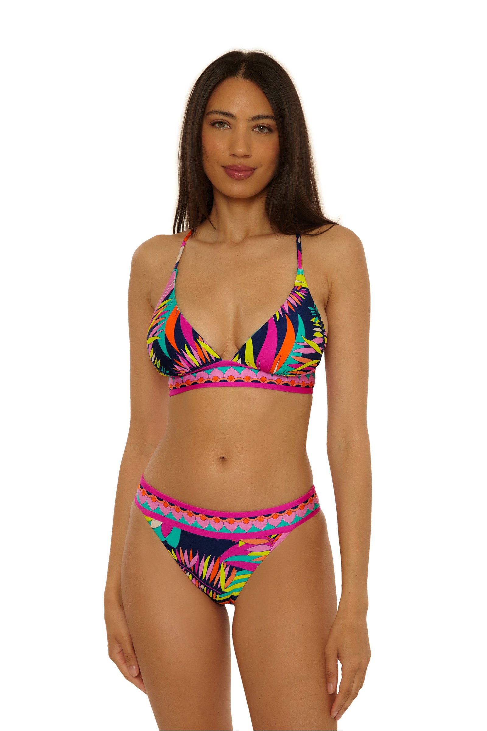 A woman in a vibrant Paralia Reversible Halter Top bikini with a triangle design and high-waisted bottoms stands against a plain white background.