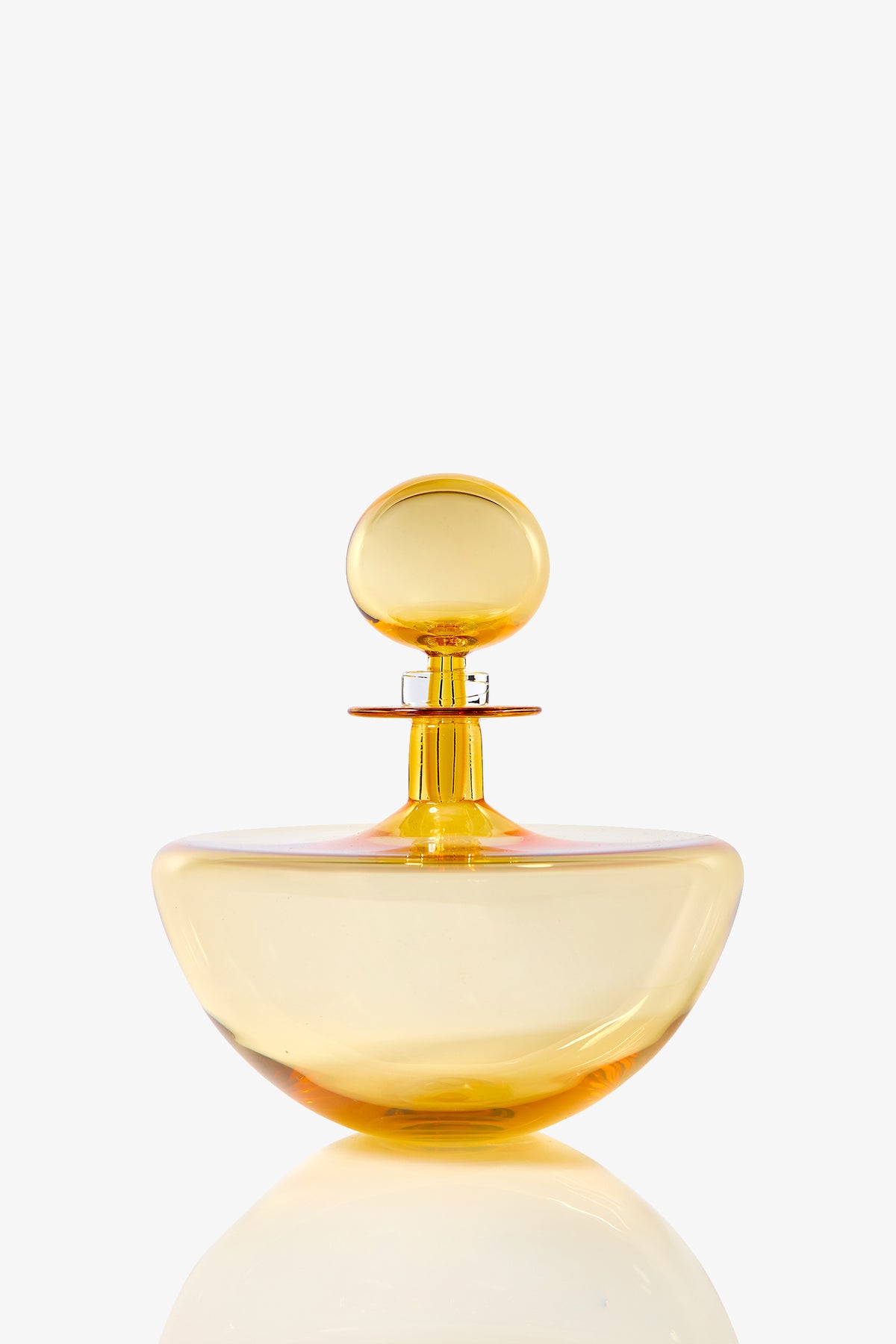 The Small Angelic Bottle is a round, translucent yellow glass perfume bottle with a matching spherical stopper, displayed on a plain white background.
