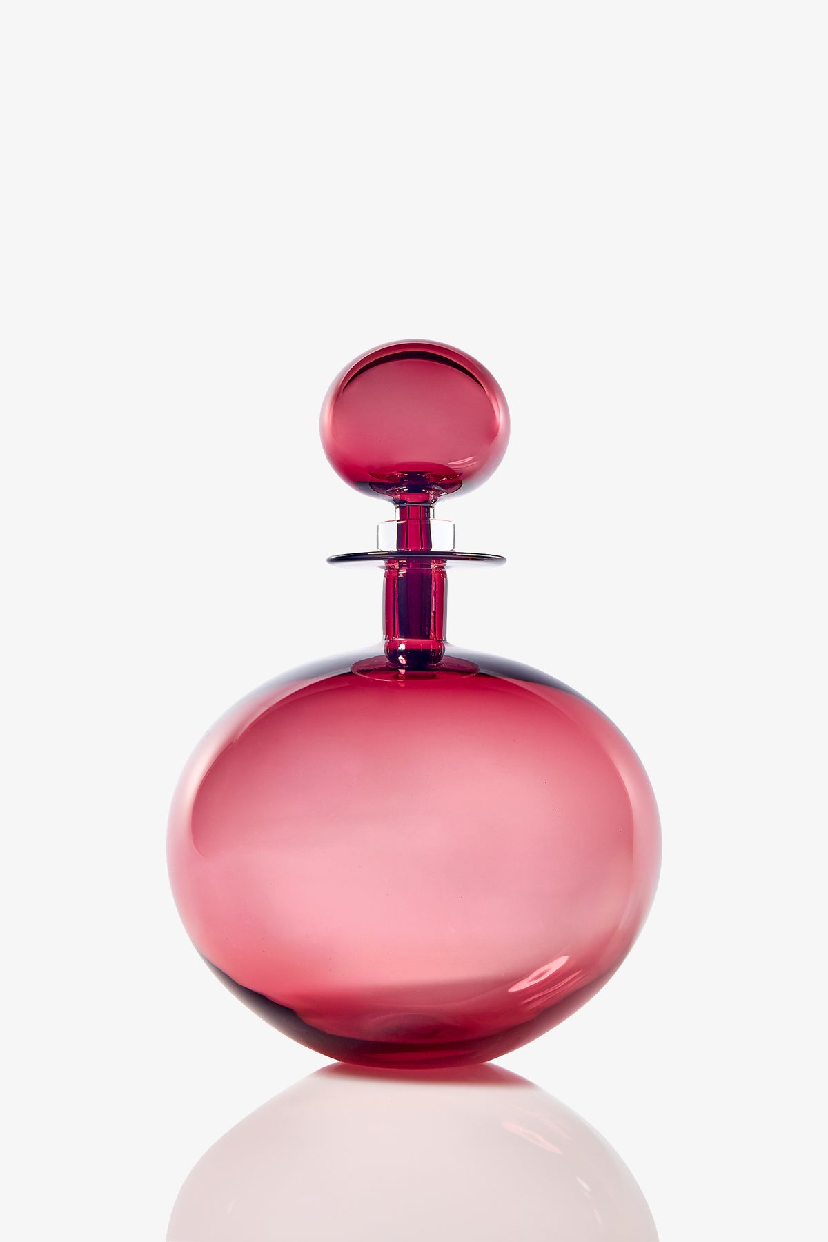 The Small Angelic Bottle is a round, elegant perfume bottle made of translucent pink glass with a matching spherical stopper, displayed against a plain white background.