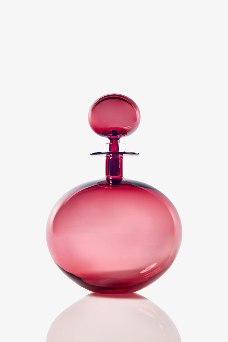 The Small Angelic Bottle is a round, elegant perfume bottle made of translucent pink glass with a matching spherical stopper, displayed against a plain white background.