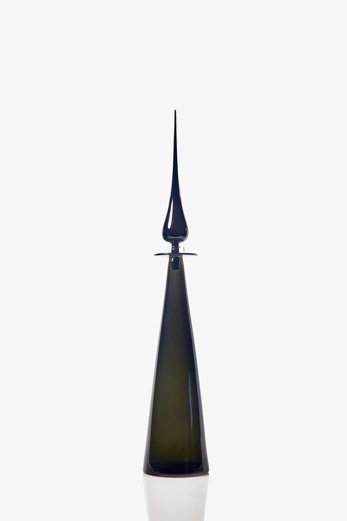 A sleek, modern Petite Straight Cone Decanter in tall, dark green glass with a pointed, elongated stopper stands against a plain white background. The decanter features a reflective surface and minimalist design.