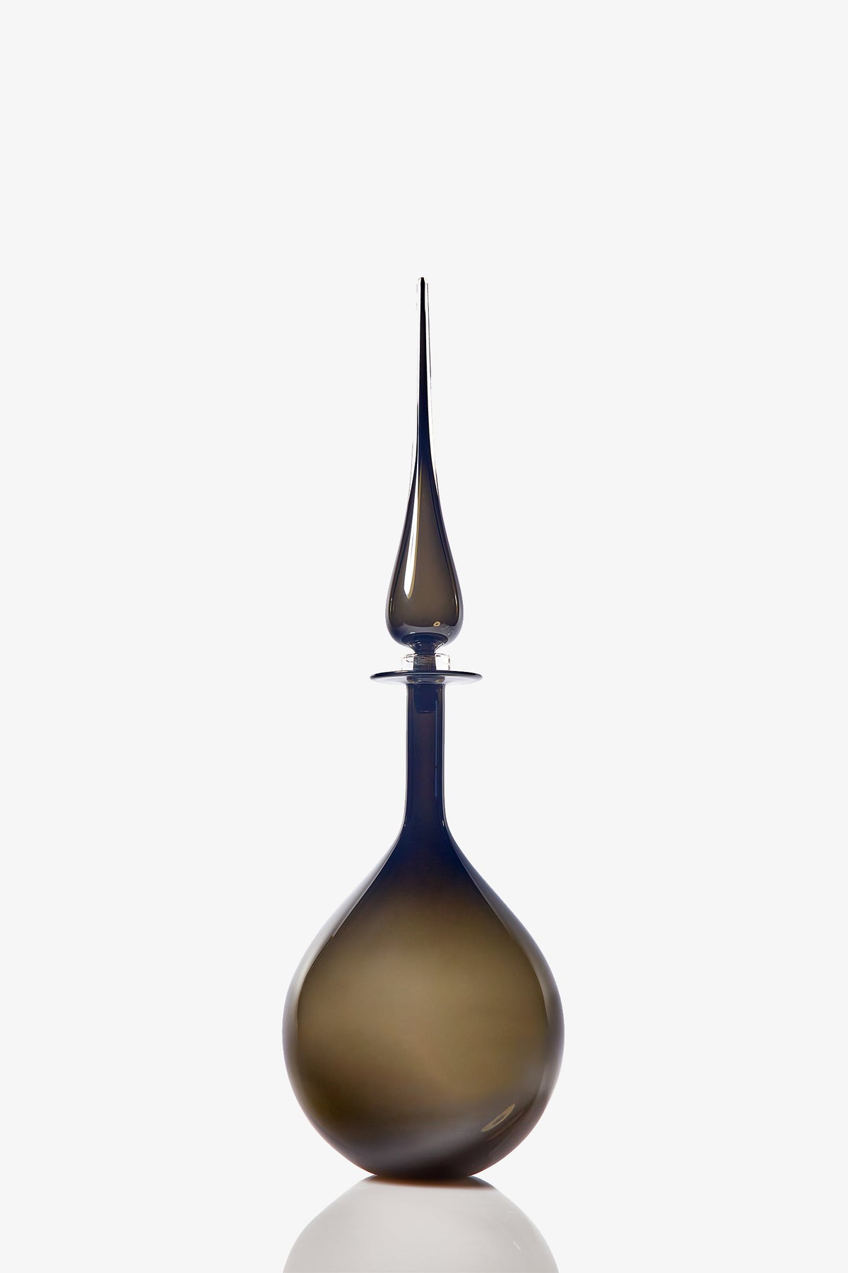 The Petite Tear Drop Decanter features smoky glass with a wide round base and a tall, slender, pointed stopper, shown against a white background.