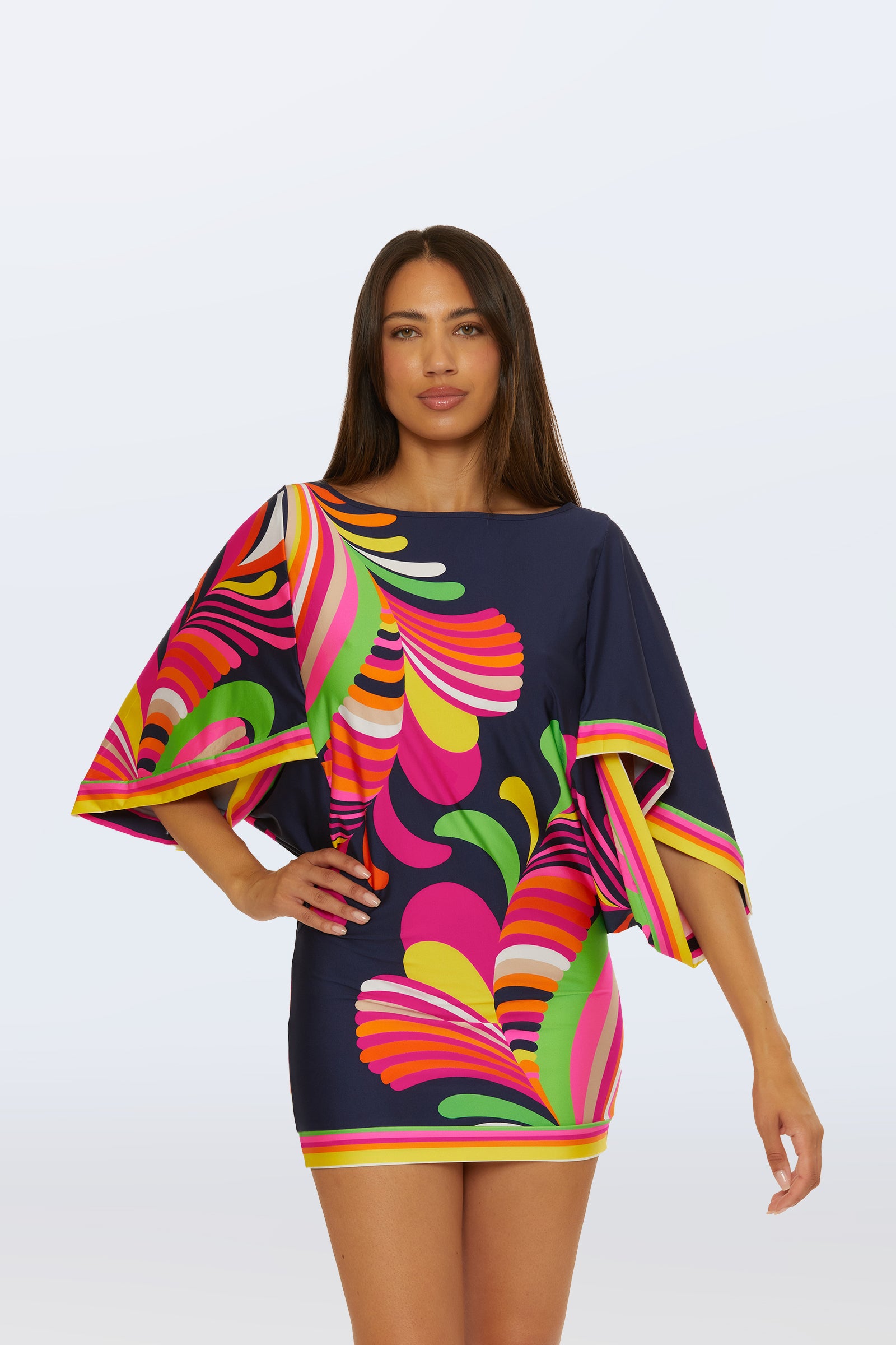 A woman with long straight hair models the Casablanca Swim Tunic - Palms Paradise in a multi-color abstract palm print against a plain light background.