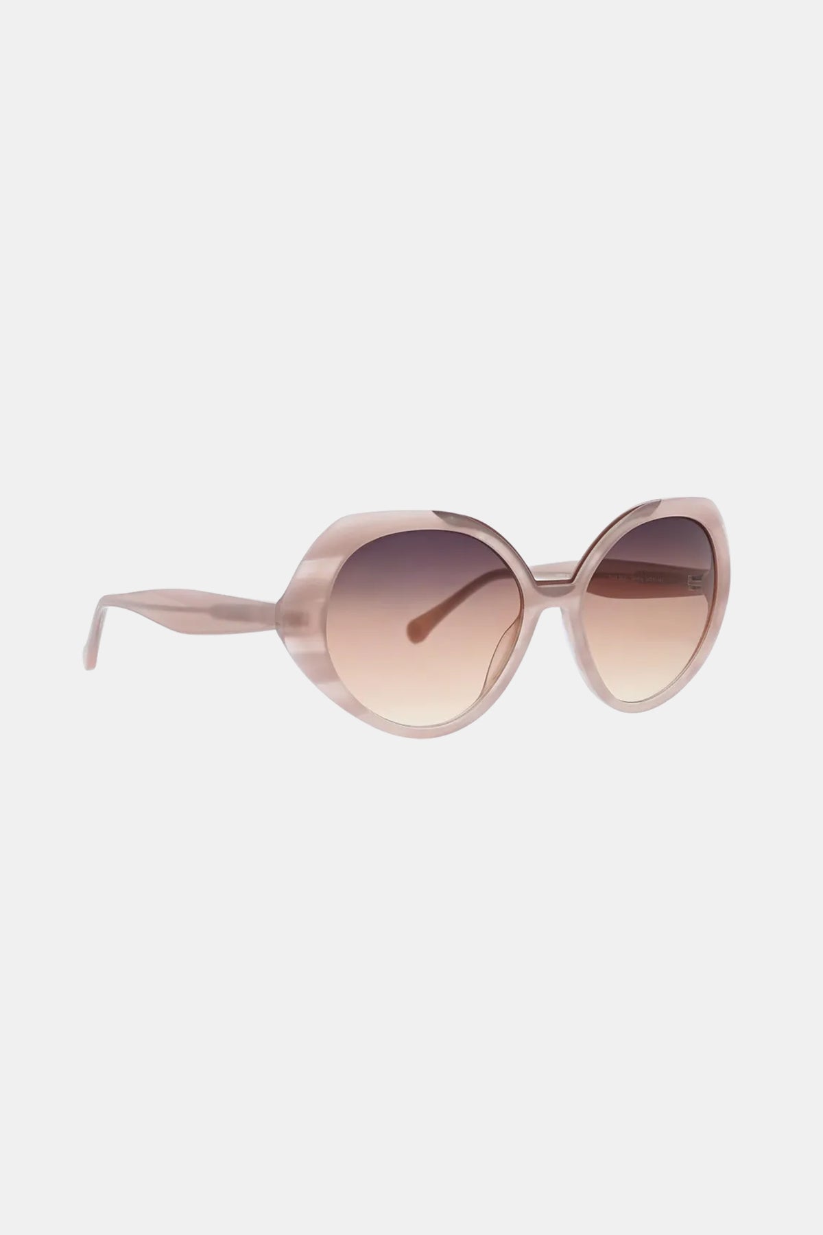 The Sandcut Sunglass features oversized, round frames in translucent pink with gradient brown lenses, shown against a plain white background.