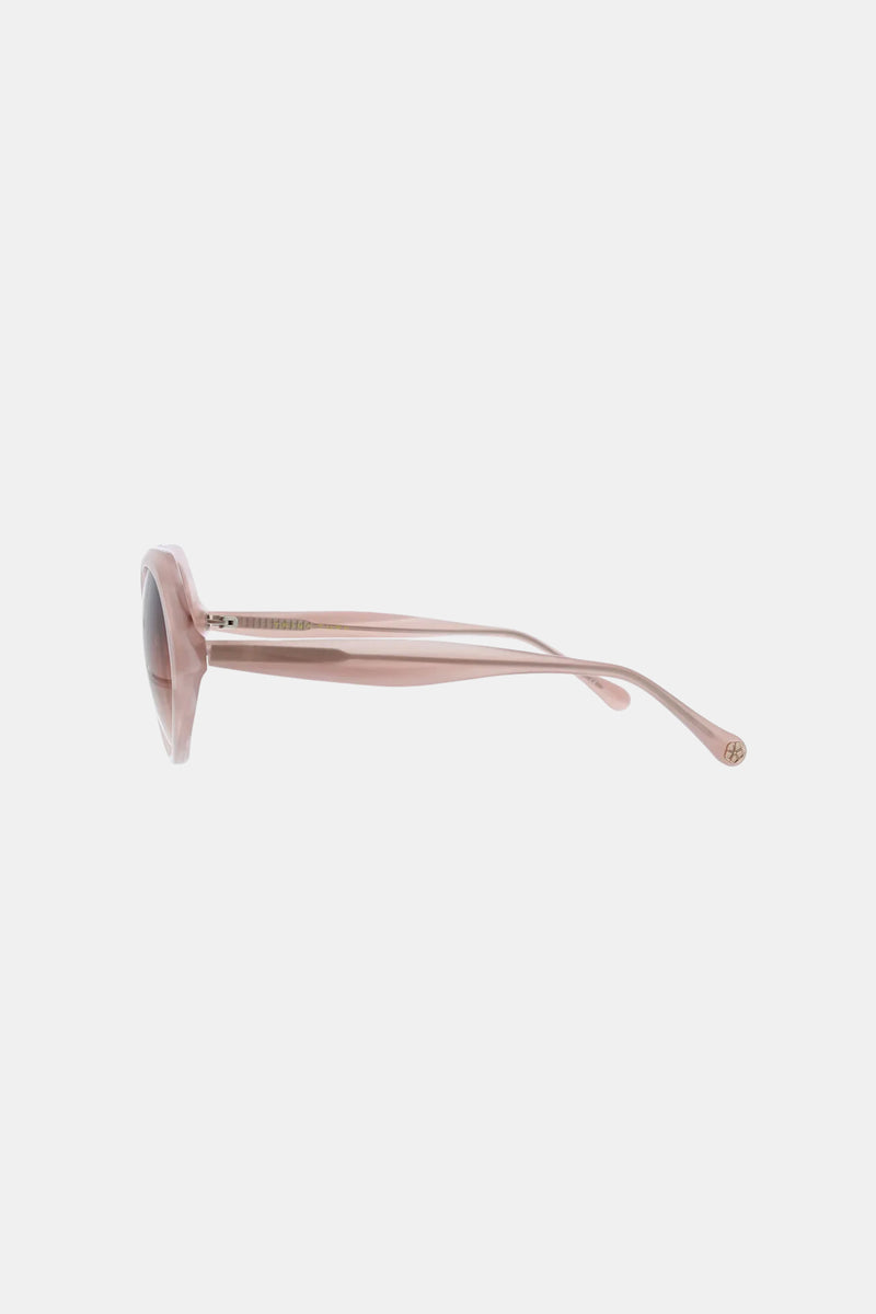 Side view of Sandcut Sunglass featuring pink, round frames, tinted lenses, and thick arms on a plain white background.