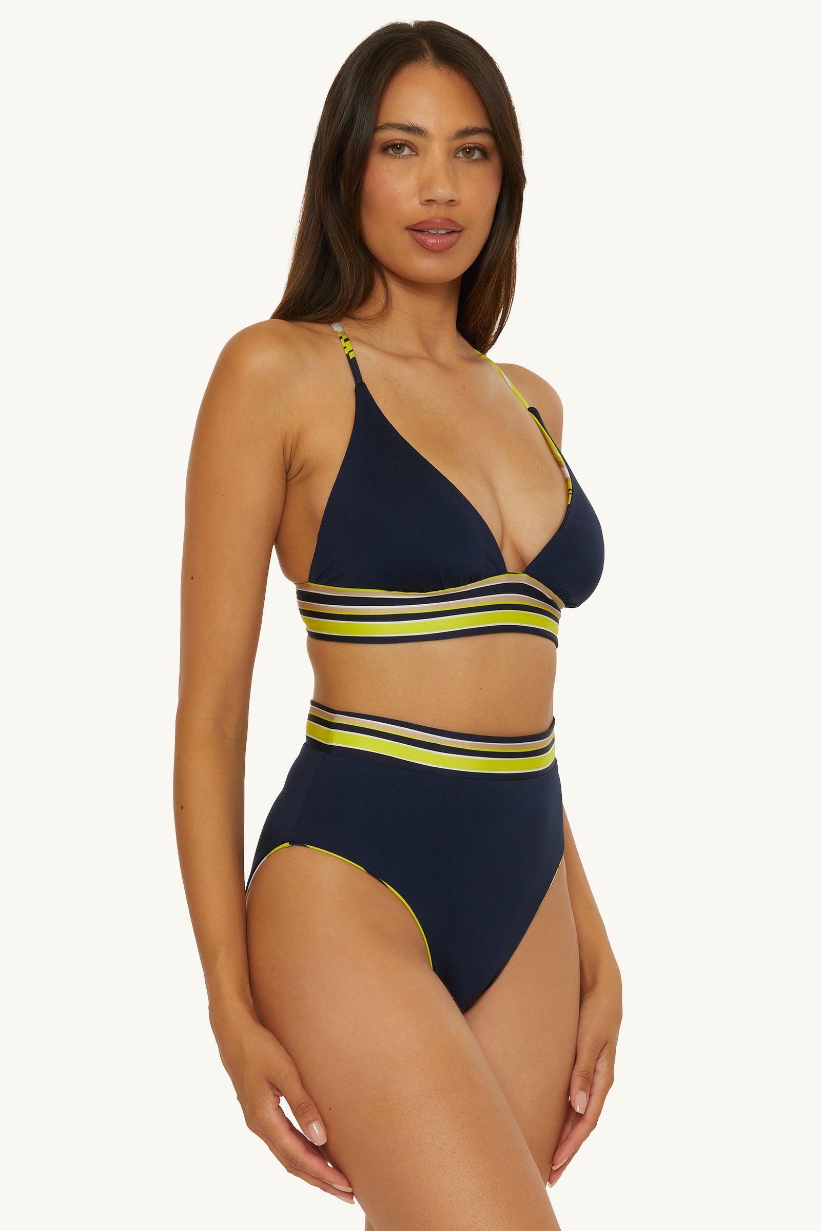 A woman models the Reversible High-Waist Swim Bottom - Serena Swirl, standing against a light background and looking at the camera with a neutral expression.