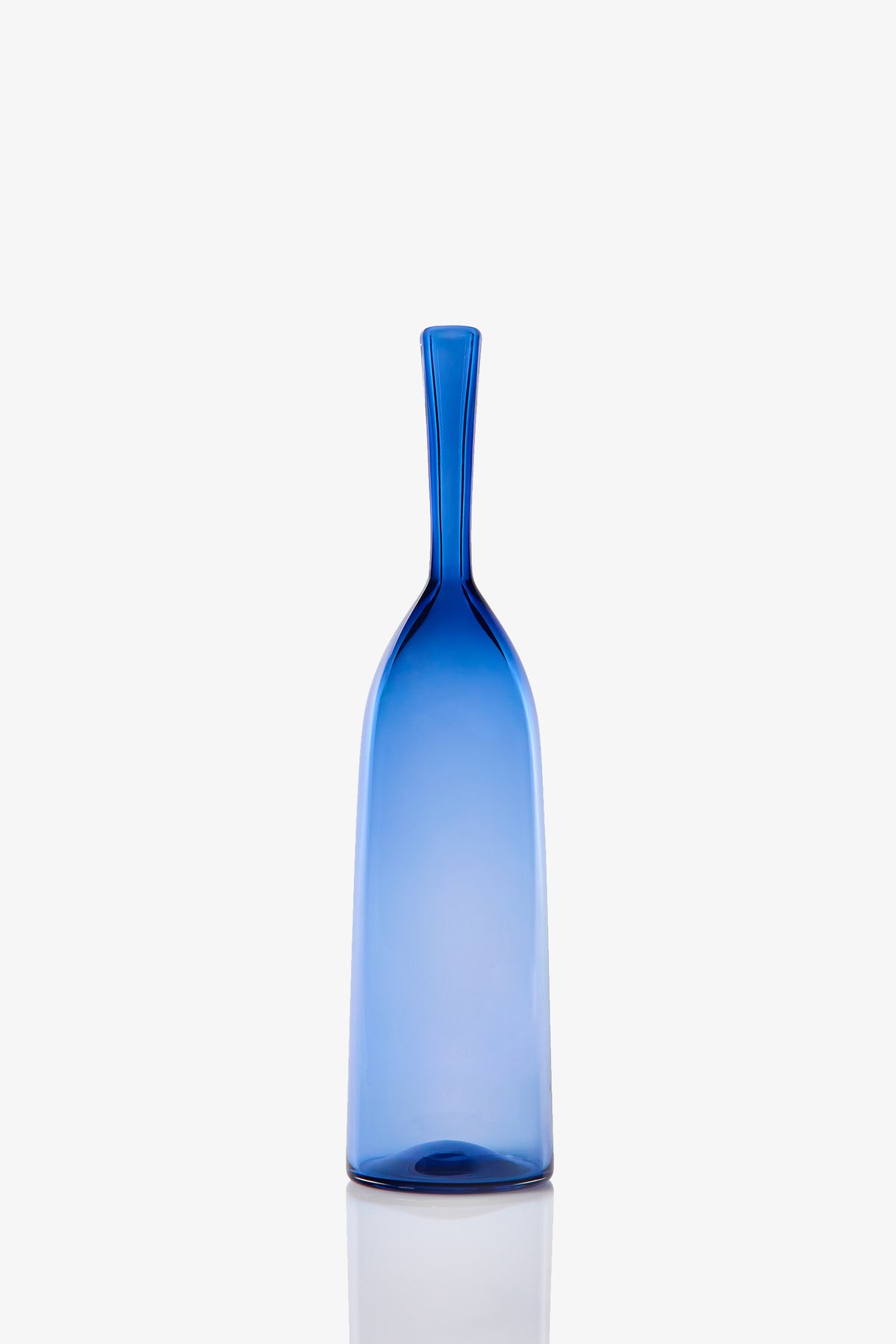 The Small Angelic Bottle is a tall, slender blue glass bottle with a narrow neck and smooth surface, shown upright against a plain white background.