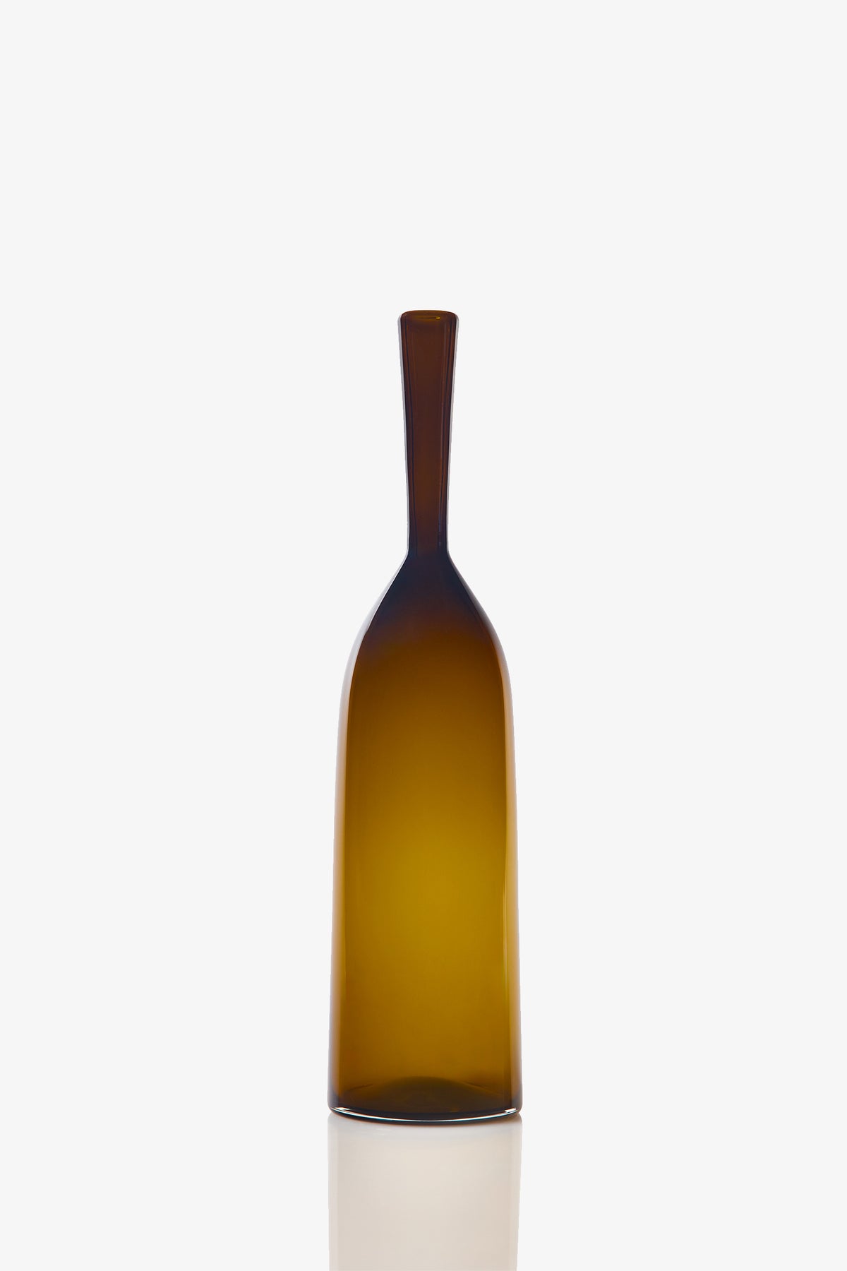 The Small Angelic Bottle is a tall, slender brown glass bottle with a narrow neck and smooth surface, shown against a plain white background and casting a soft reflection below.