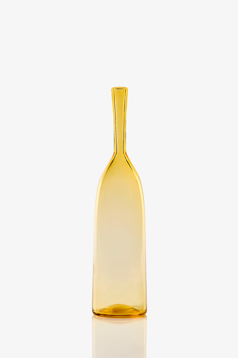 The Small Angelic Bottle is a tall, slender, translucent amber glass bottle with a narrow neck and slightly flared base, shown upright on a white background.