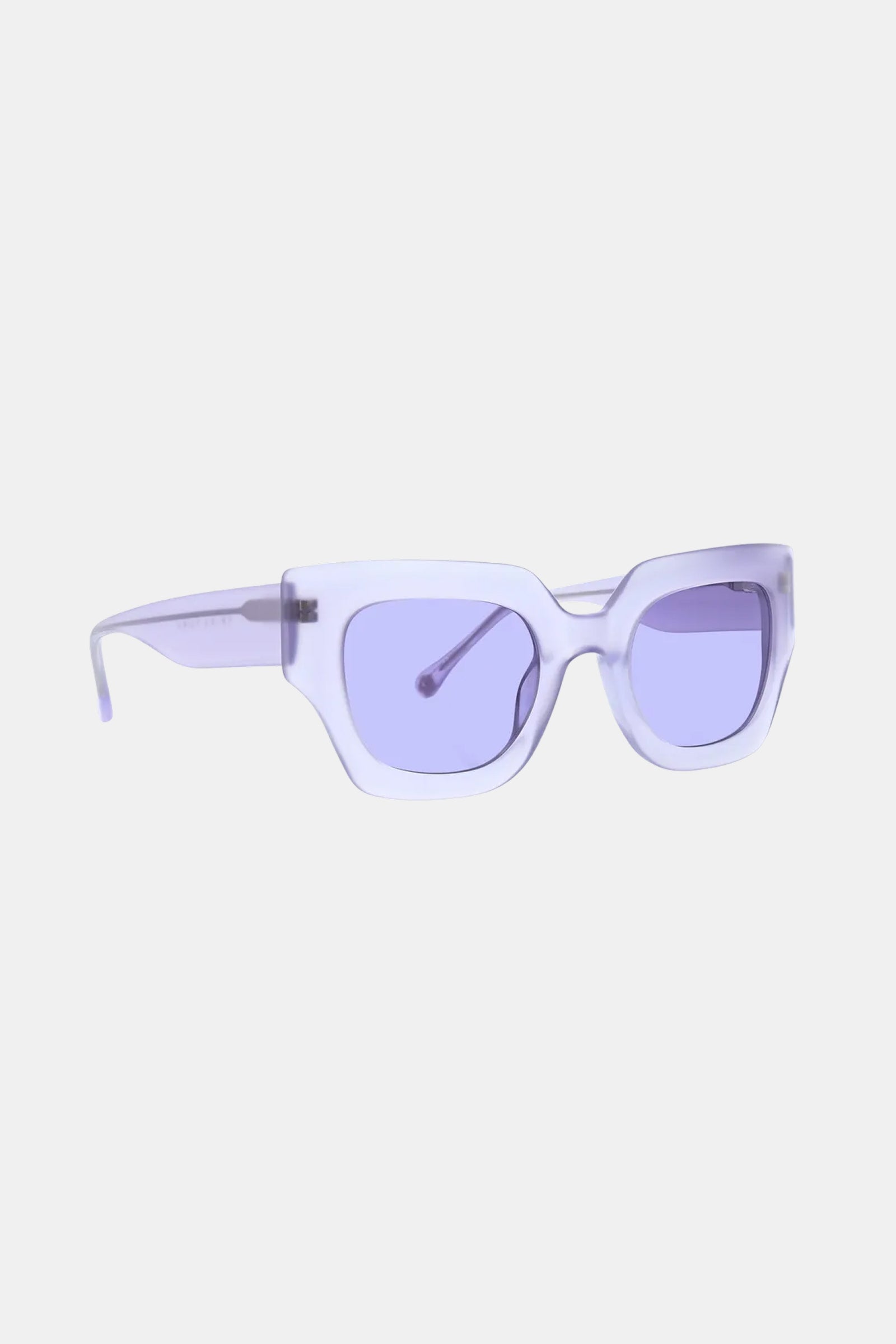 The Sol Sunglass features geometric, translucent lavender frames and purple-tinted lenses, displayed on a white background.