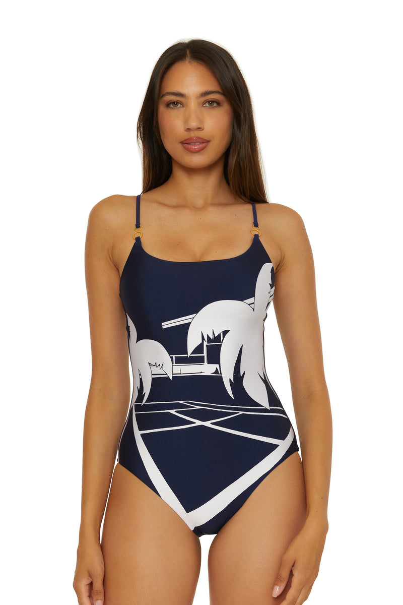 A woman models the Scoop Neck One-Piece Swimsuit - Trina Tennis in ink, featuring white palm tree and geometric patterns, standing front-facing against a plain white background.