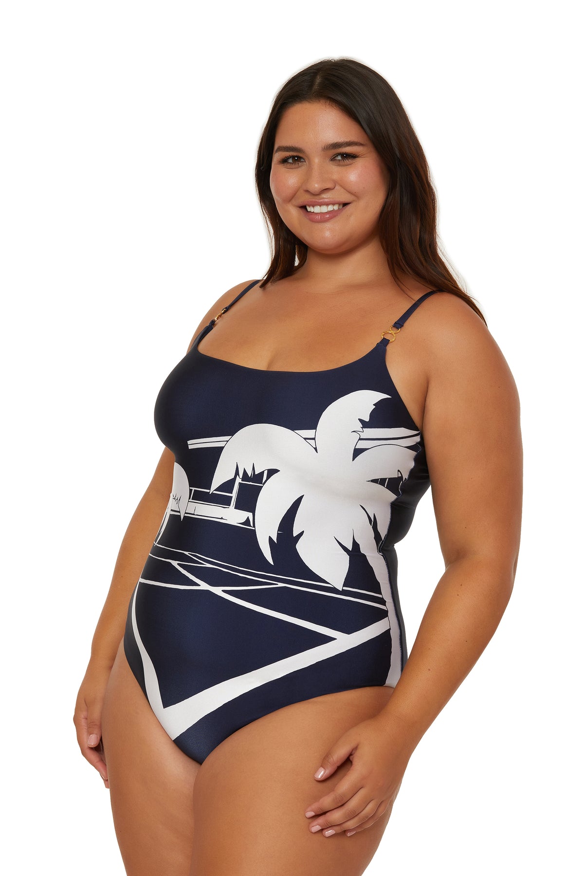 A smiling woman wears the Scoop Neck One-Piece Swimsuit - Trina Tennis, featuring a navy blue base with white palm tree and geometric designs, standing against a white background.