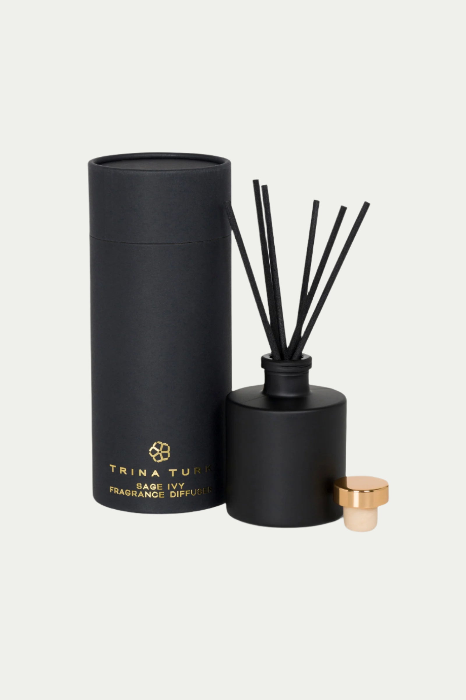 A black cylindrical TT x Perch Sage Ivy Fragrance Diffuser with a gold cap and black reeds stands beside its matching black and gold packaging, both branded with the product name.