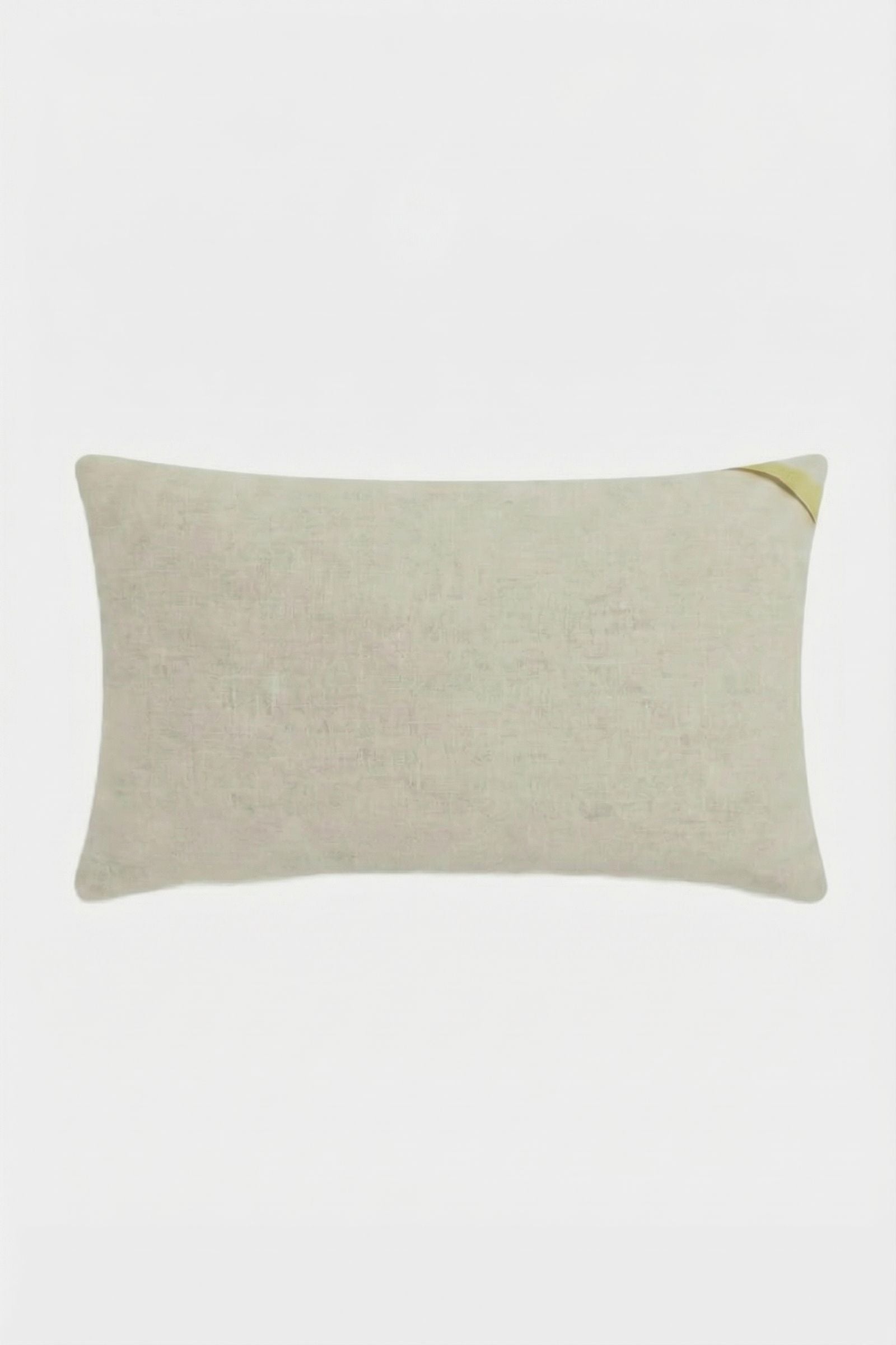 The Calistoga Embroidered Rainbow Lumbar Pillow is a rectangular beige accent pillow with a subtle woven texture and a small diagonal yellow detail on the top right, perfect as a stylish throw pillow for any space.