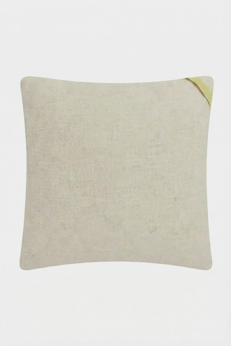The Carmel Embroidered Pillow 20x20" is a square beige throw pillow with subtle texture and a small yellow fabric loop on one corner, shown against a plain white background.