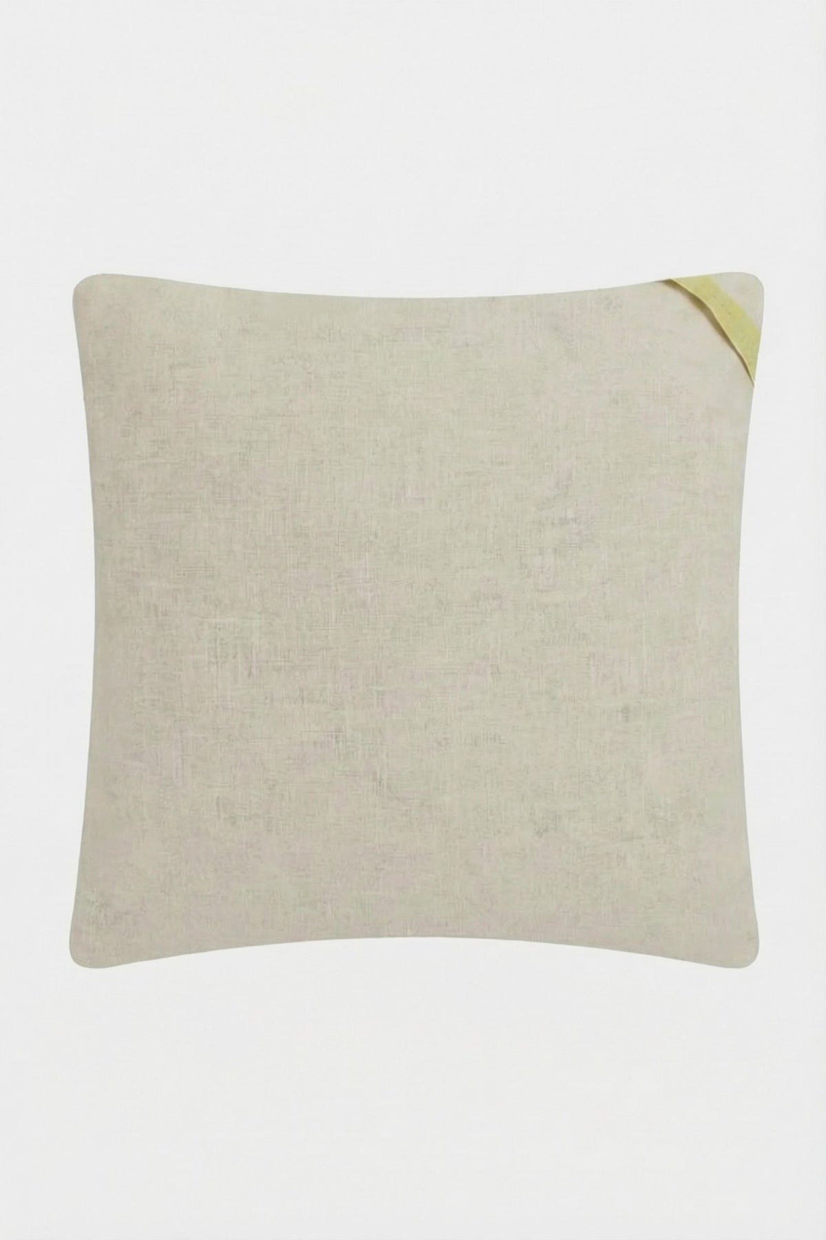 The Costa Mesa Embroidered Square Pillow is a light beige, rectangular cushion with a subtle textured pattern and a small diagonal yellow fabric loop at one corner, shown on a plain white background.