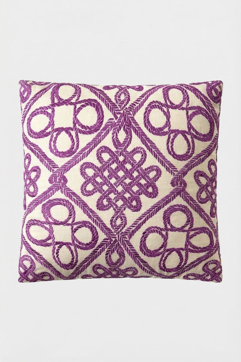 Costa Mesa Embroidered Throw Pillow featuring a cream background with intricate purple geometric and knot embroidery in a symmetrical, decorative pattern.