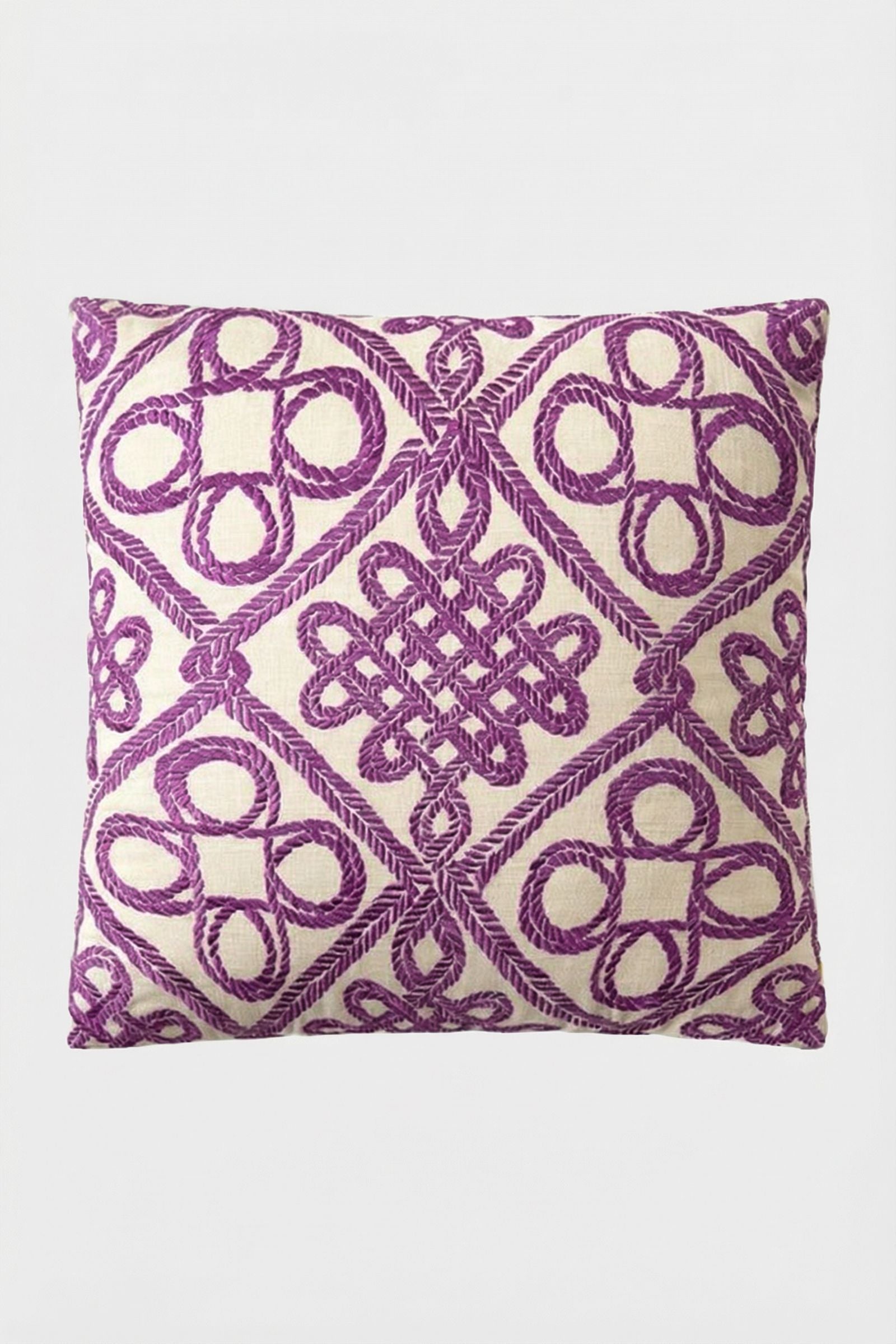 Costa Mesa Embroidered Throw Pillow featuring a cream background with intricate purple geometric and knot embroidery in a symmetrical, decorative pattern.