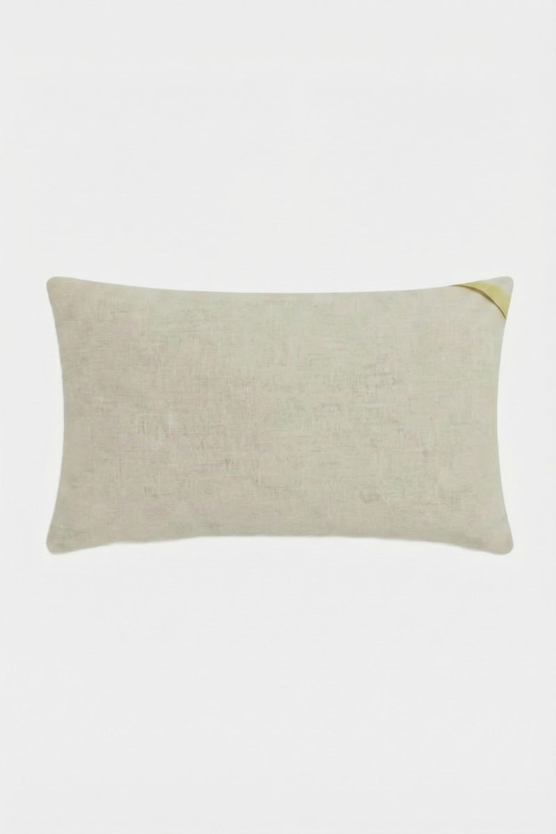 The Escondido Embroidered Lumbar Pillow is a rectangular light beige pillow with a small yellow corner accent, shown on a plain white background.