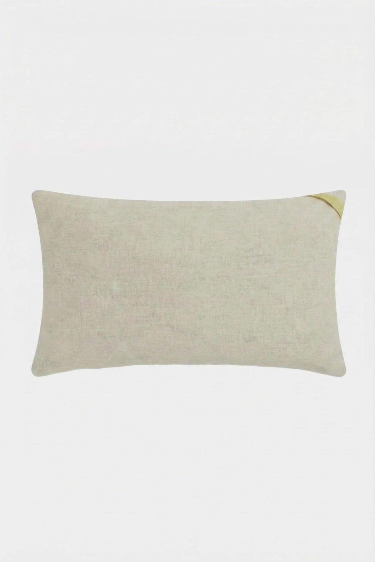 The Roseville Embroidered Lumbar Pillow is rectangular and light beige with a subtle texture and a small golden accent on the top right corner, displayed against a plain white background.