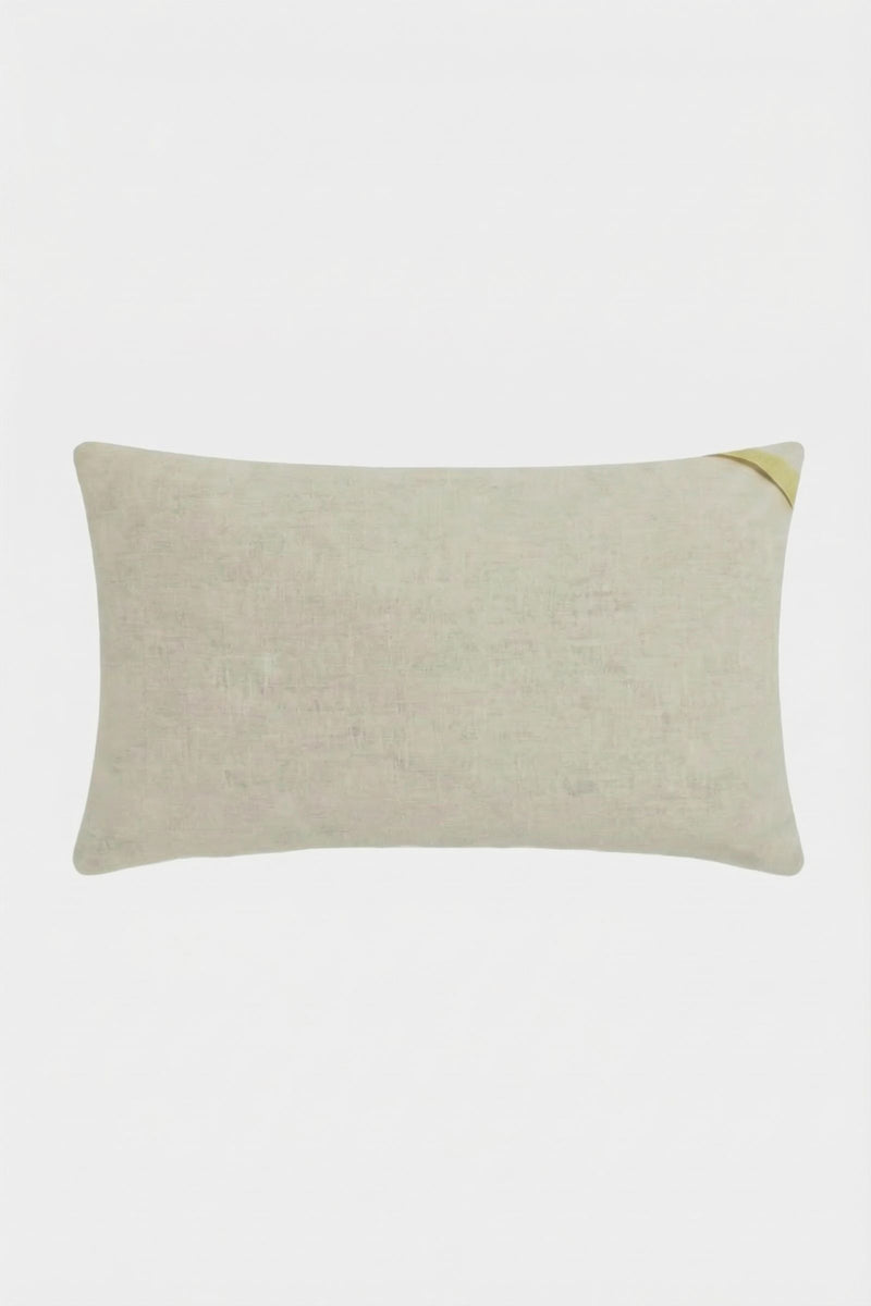 The Roseville Embroidered Lumbar Pillow is rectangular and light beige with a subtle texture and a small golden accent on the top right corner, displayed against a plain white background.