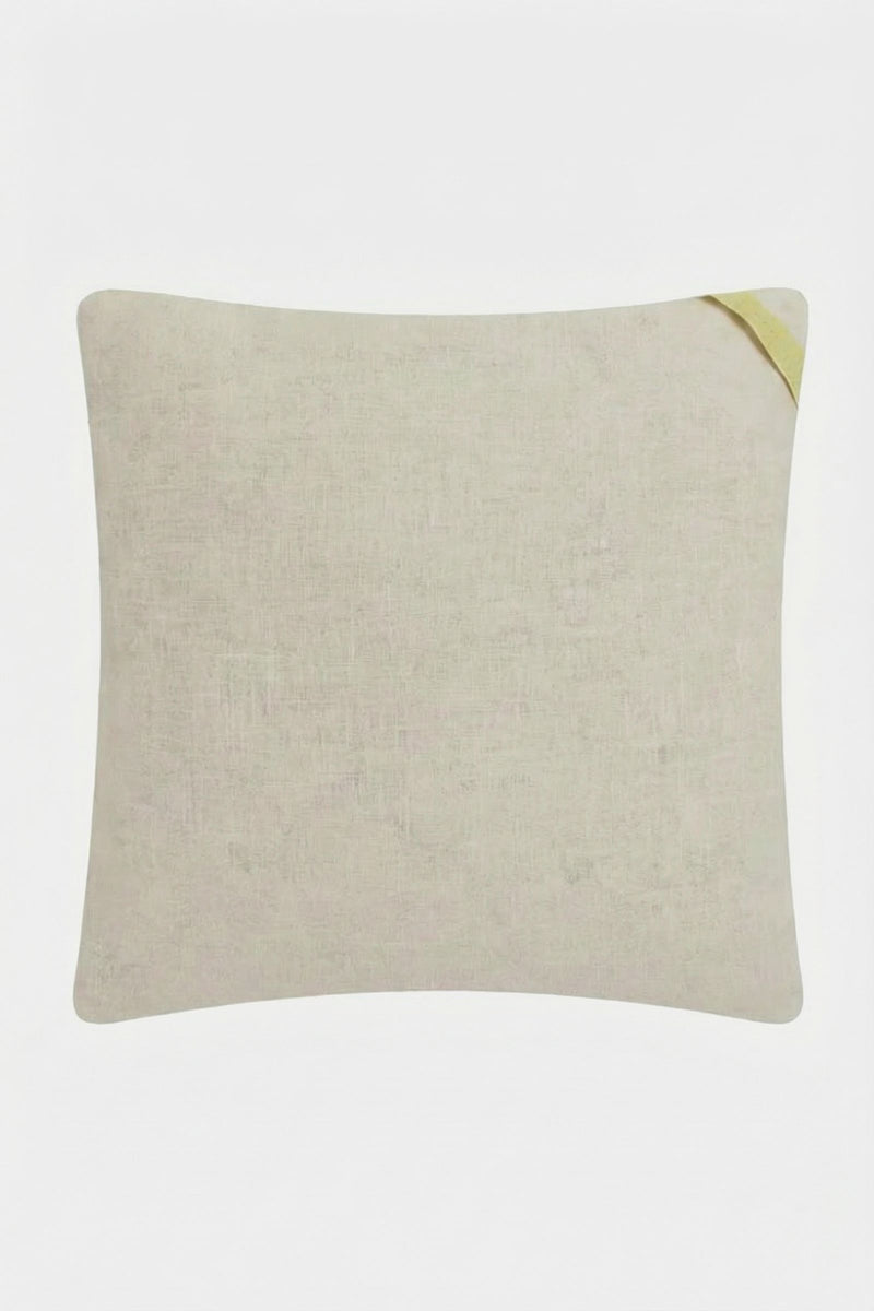 The Shante Embroidered Pillow is a square beige pillow with a textured fabric surface and a small yellow fabric tab on the top right corner, shown on a plain white background.