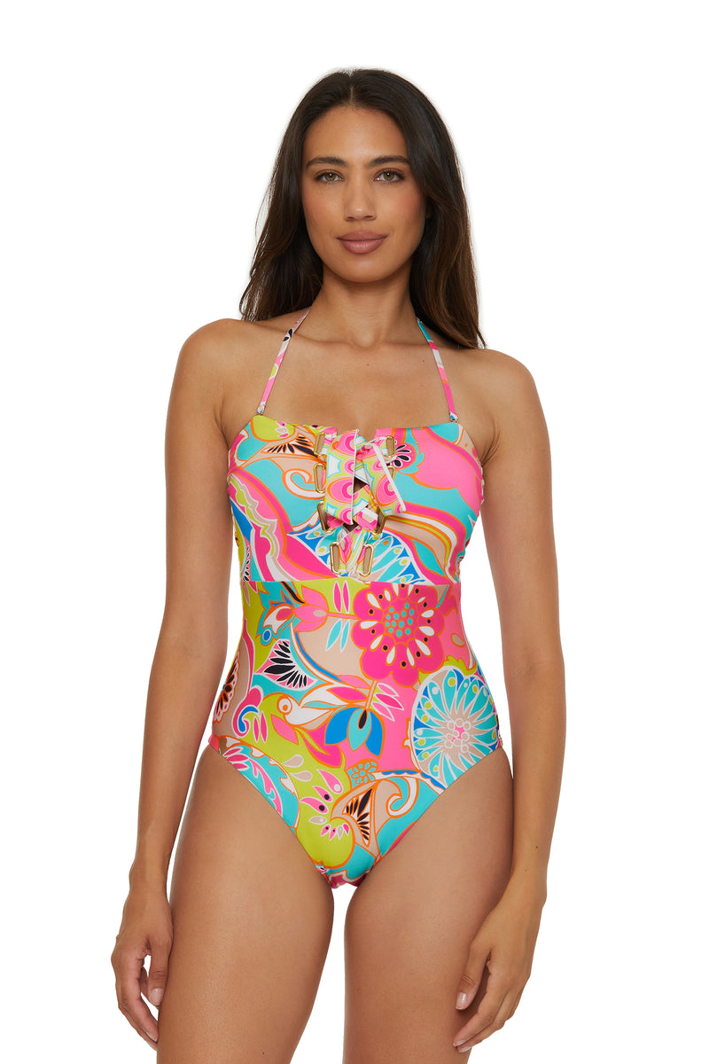 A woman wears the Lace-Up Bandeau One-Piece Swimsuit in Venus Swim, featuring ruffle detailing on the chest. She stands facing forward with arms relaxed at her sides.