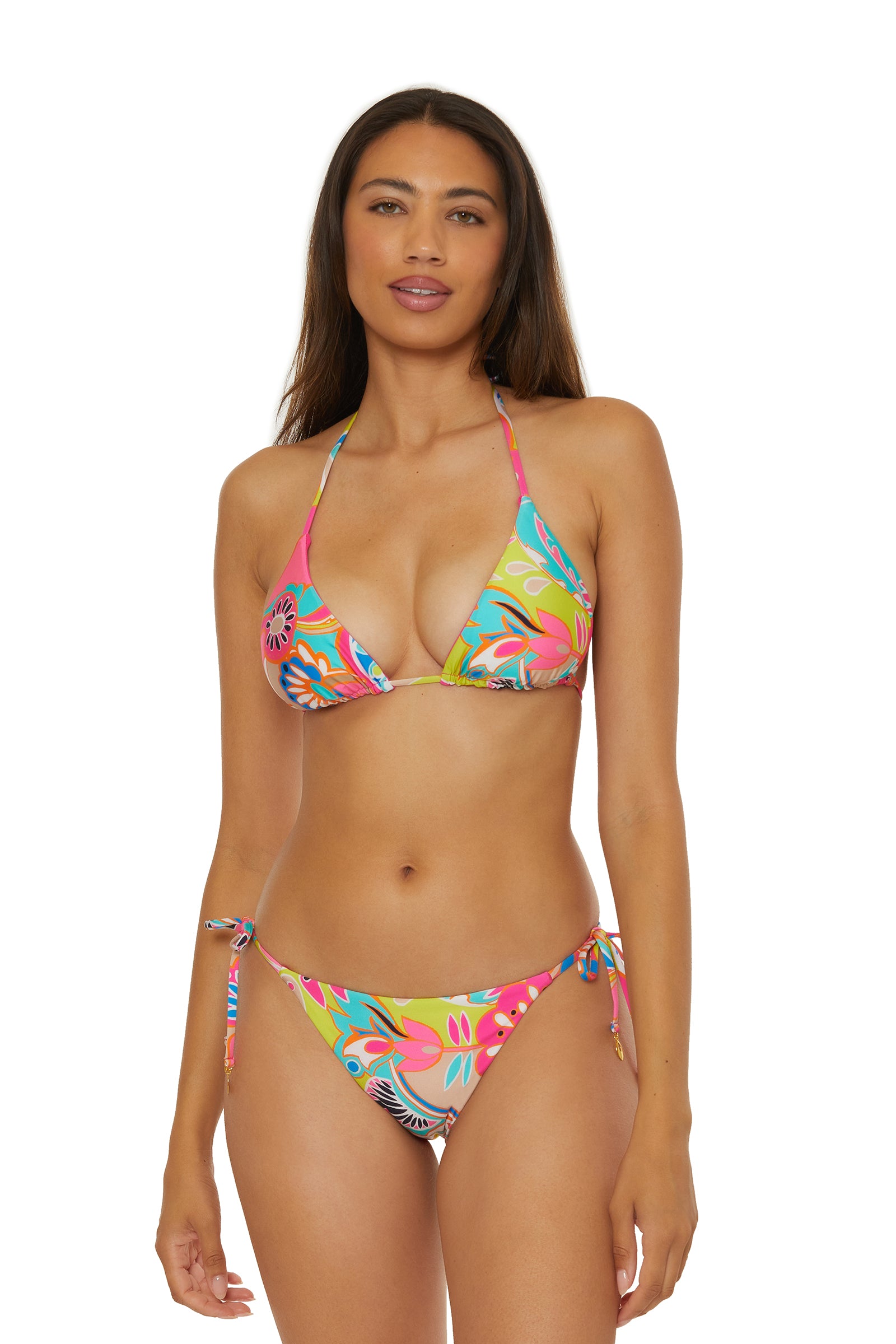 A woman with long brown hair and a neutral expression stands facing forward in the Reversible Tie Side Swim Bottom - Venus, featuring side-tie bottoms and a triangle top, posing against a plain white background.