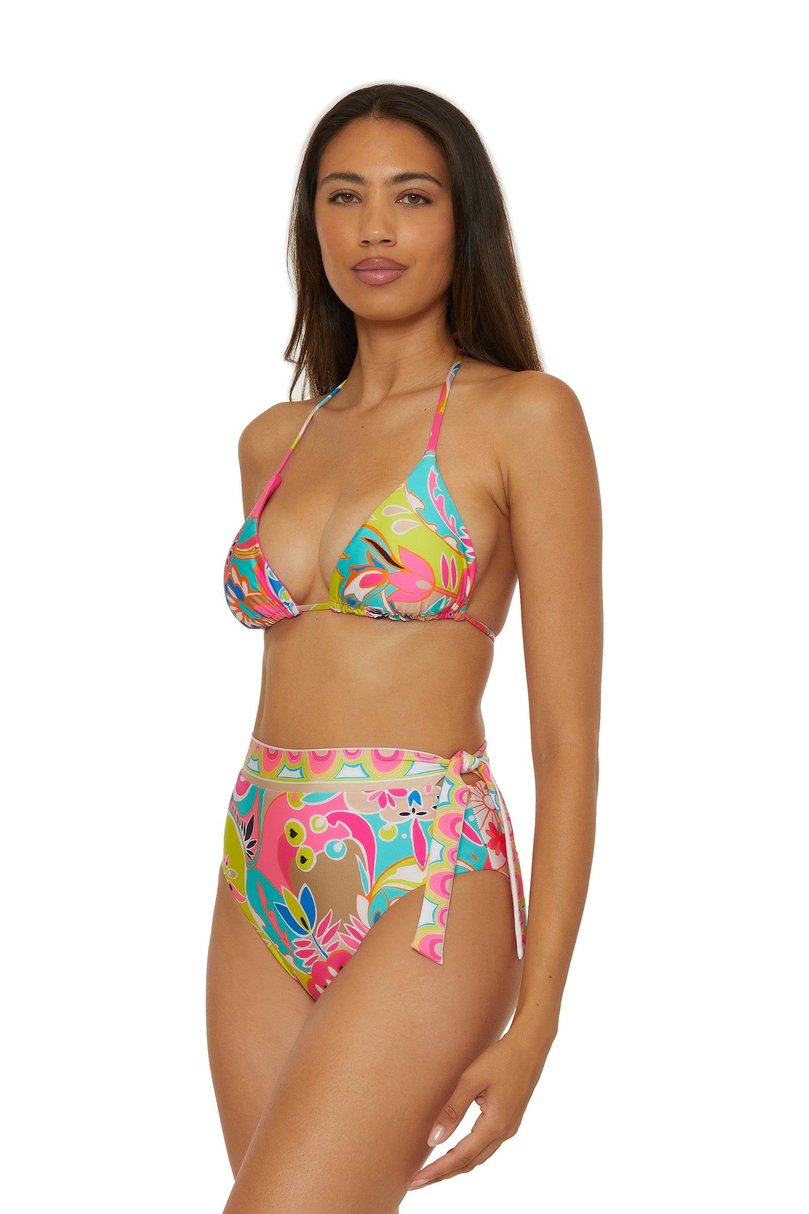 A woman models the Reversible Triangle Swim Top - Venus, featuring a colorful floral print, standing against a white background and smiling softly.