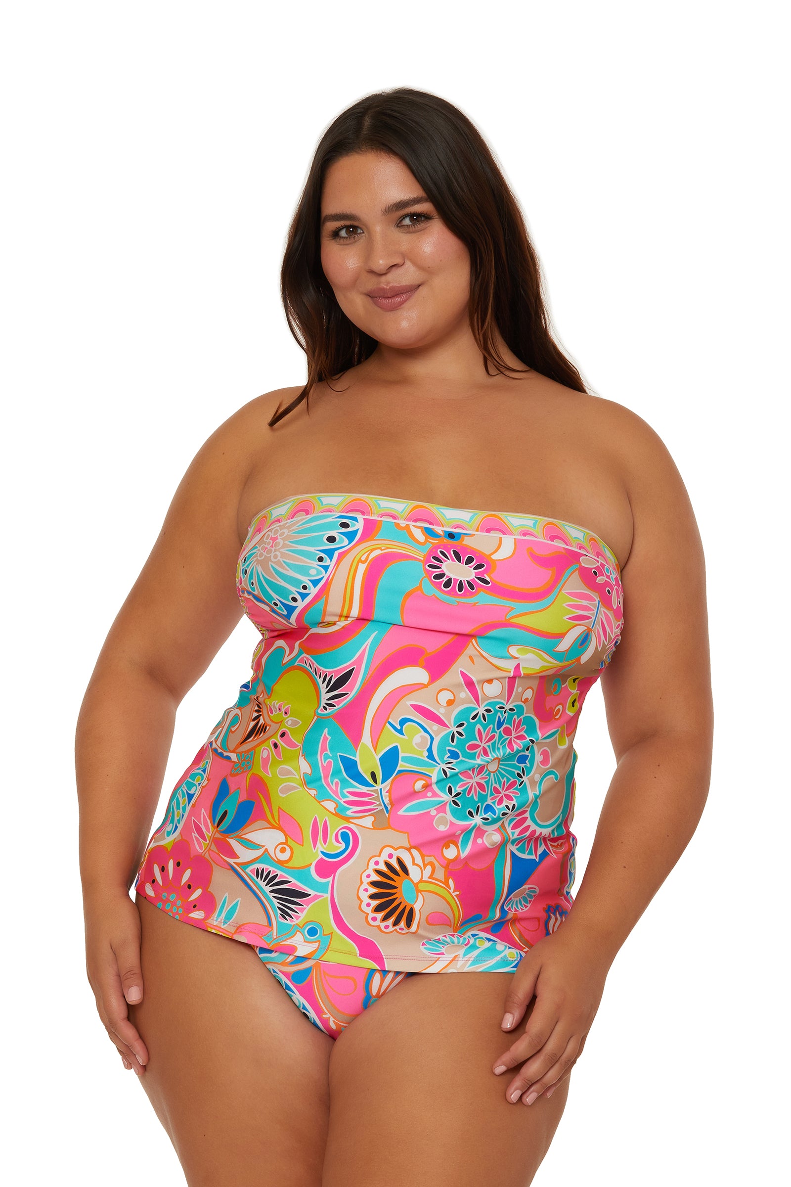 A woman smiles at the camera against a white background, wearing the Venus Banded Tankini Swim Top in a colorful floral print.