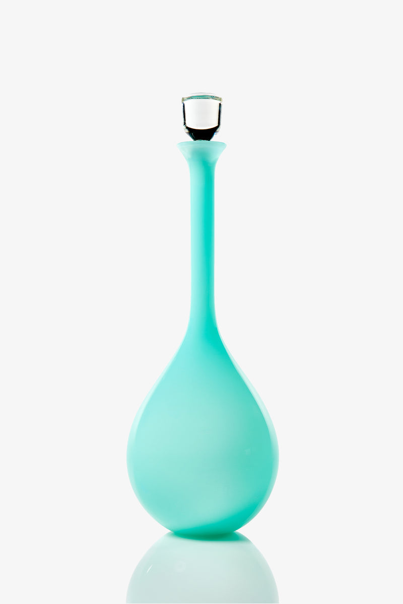 A Wexler Tear Drop Bottle, tall and slender with a turquoise glass body, wide round base, and clear glass stopper, photographed against a white background.
