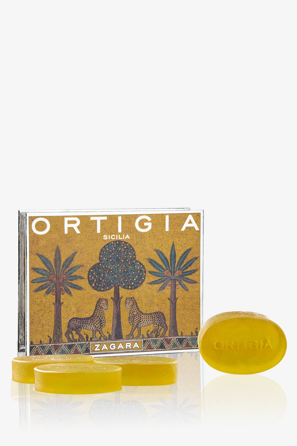 The Ortigia Soap 4P Set features four yellow oval soaps—one embossed with Ortigia—displayed before a gold Ortigia Sicilia Zagara box adorned with palm trees and leopards.