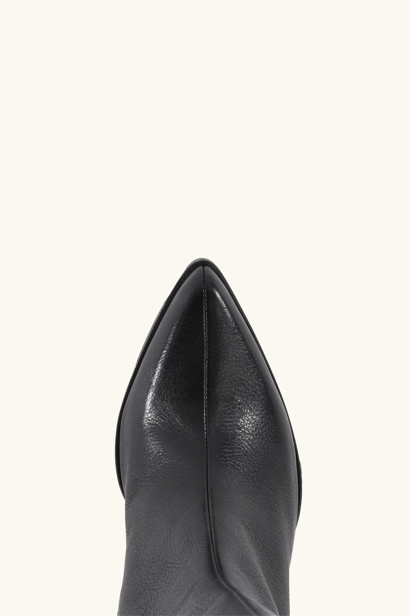 Close-up top view of the pointed toe of the Begging You Leather Boot in black, shown against a plain light background.
