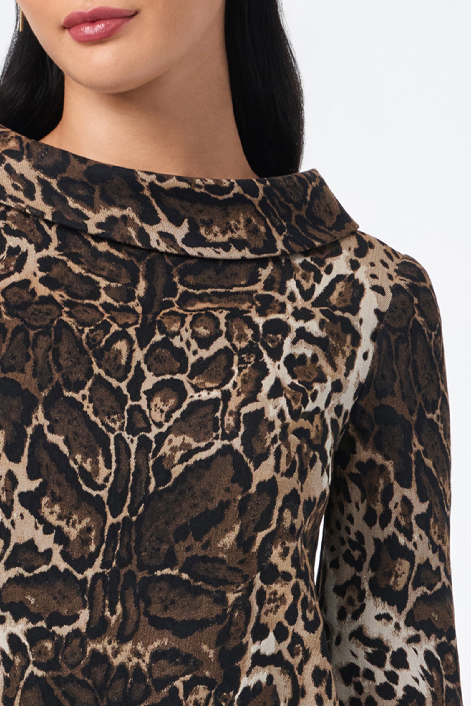 A woman wears the Kailee Top—a long-sleeve, brown and black leopard print top with a wide, folded collar. Only her lower face, neck, and upper torso are shown.