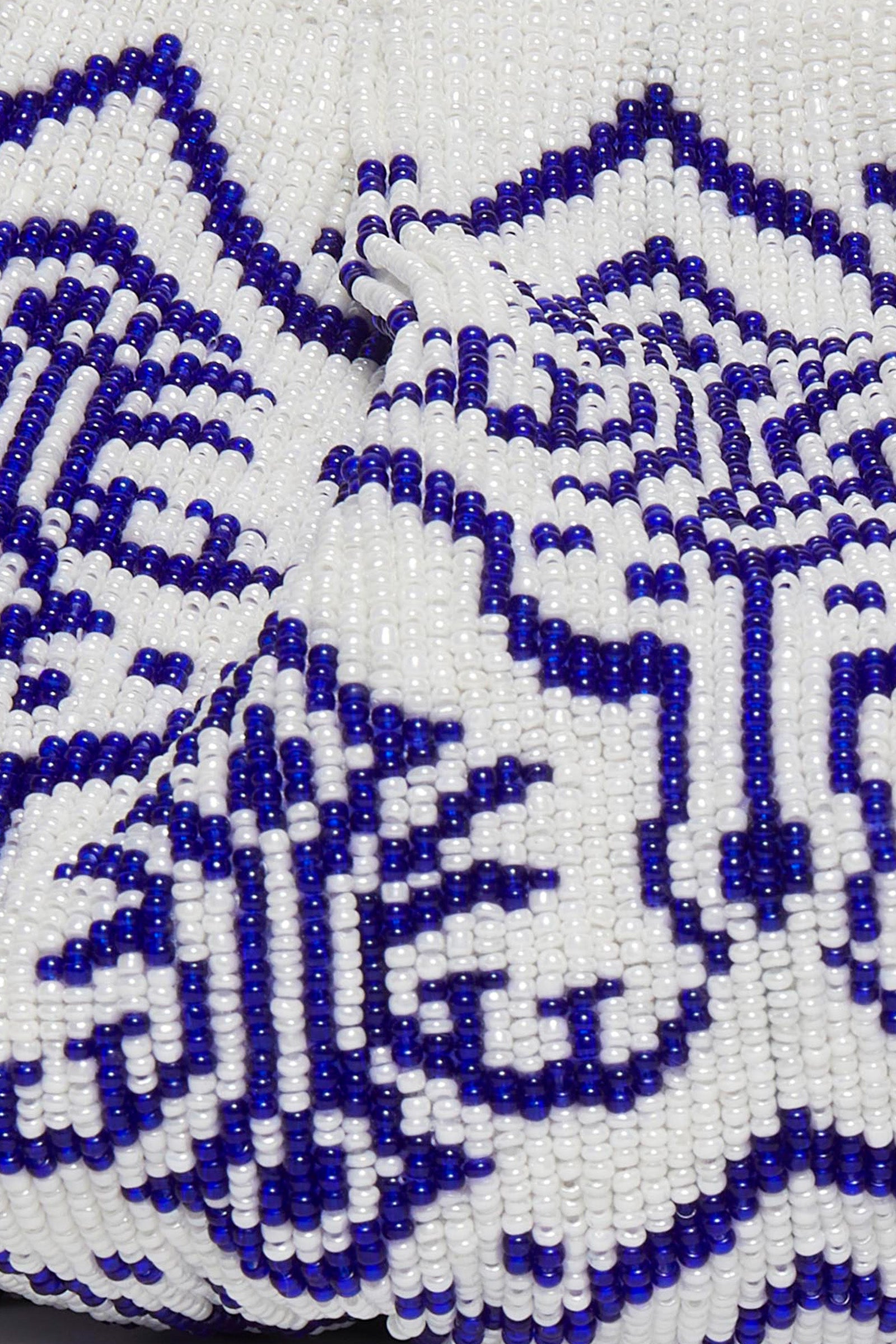 Close-up of the Blue Ivory Cora Bead Clutch, showcasing intricate beadwork with a bold blue geometric pattern on a white background.