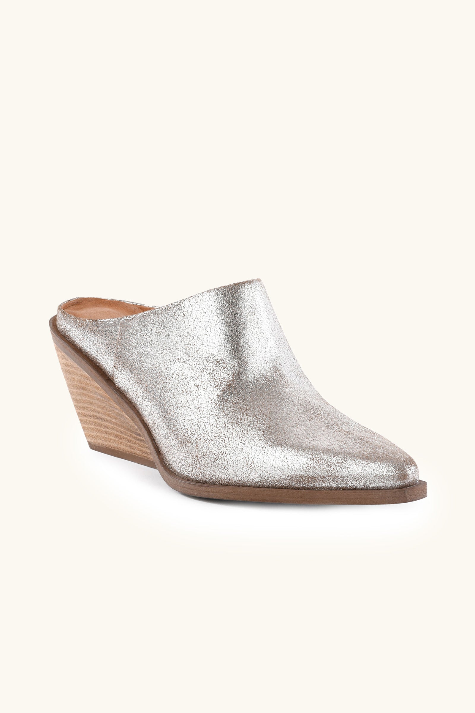 The Seychelles Morning Joe Mule is a silver metallic shoe with a pointed toe and stacked wooden wedge heel, shown against a light background.