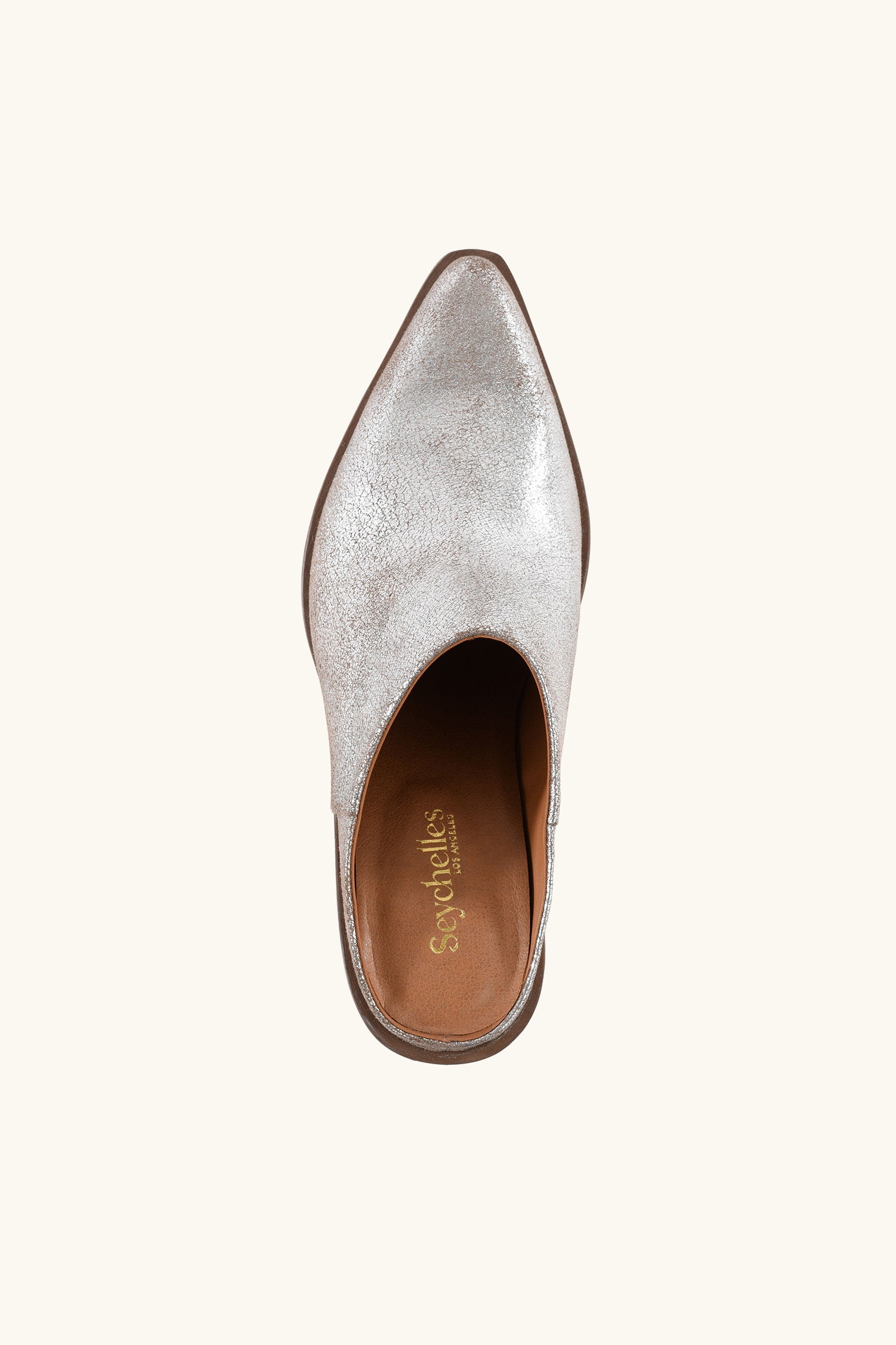 Top view of a single Seychelles Morning Joe Mule in silver, featuring a pointed toe, slip-on design, brown insole, and Seychelles brand name in gold lettering inside.
