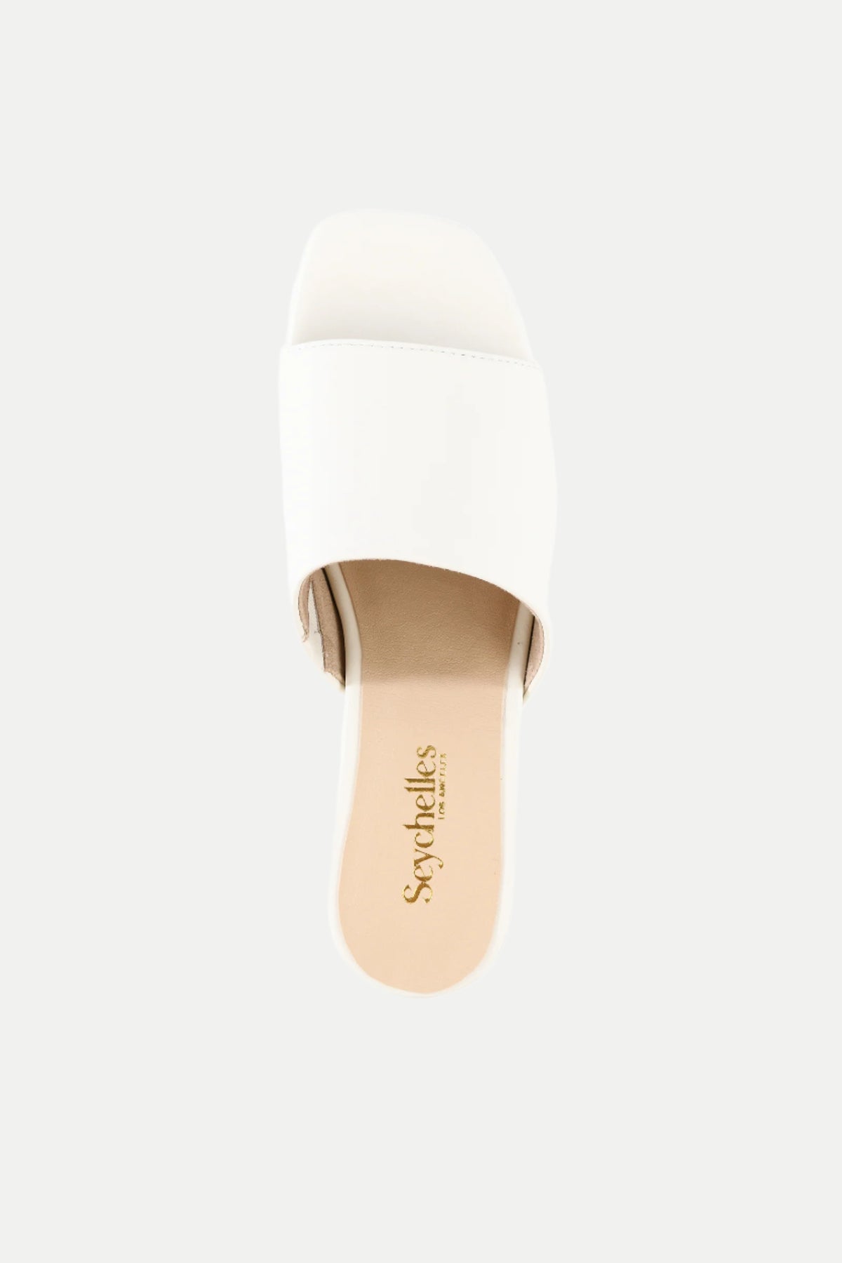 The Pepper White Leather Heeled Mule Sandal features a single wide strap, a beige insole, and the Seychelles logo, shown from a top-down view against a plain background.