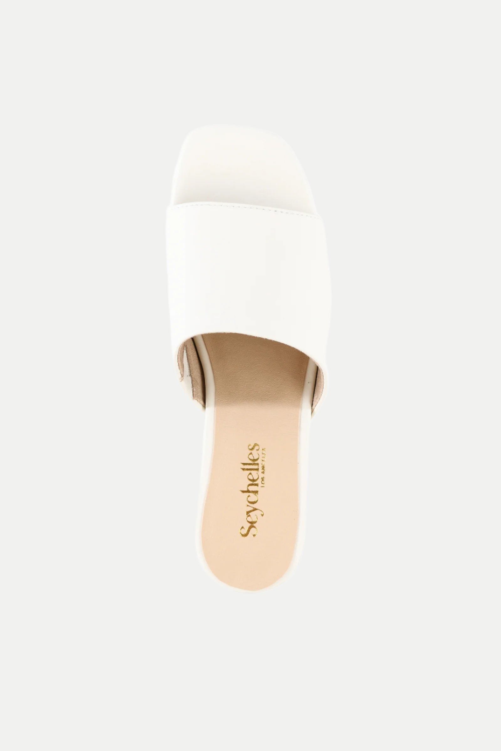 The Pepper White Leather Heeled Mule Sandal features a single wide strap, a beige insole, and the Seychelles logo, shown from a top-down view against a plain background.