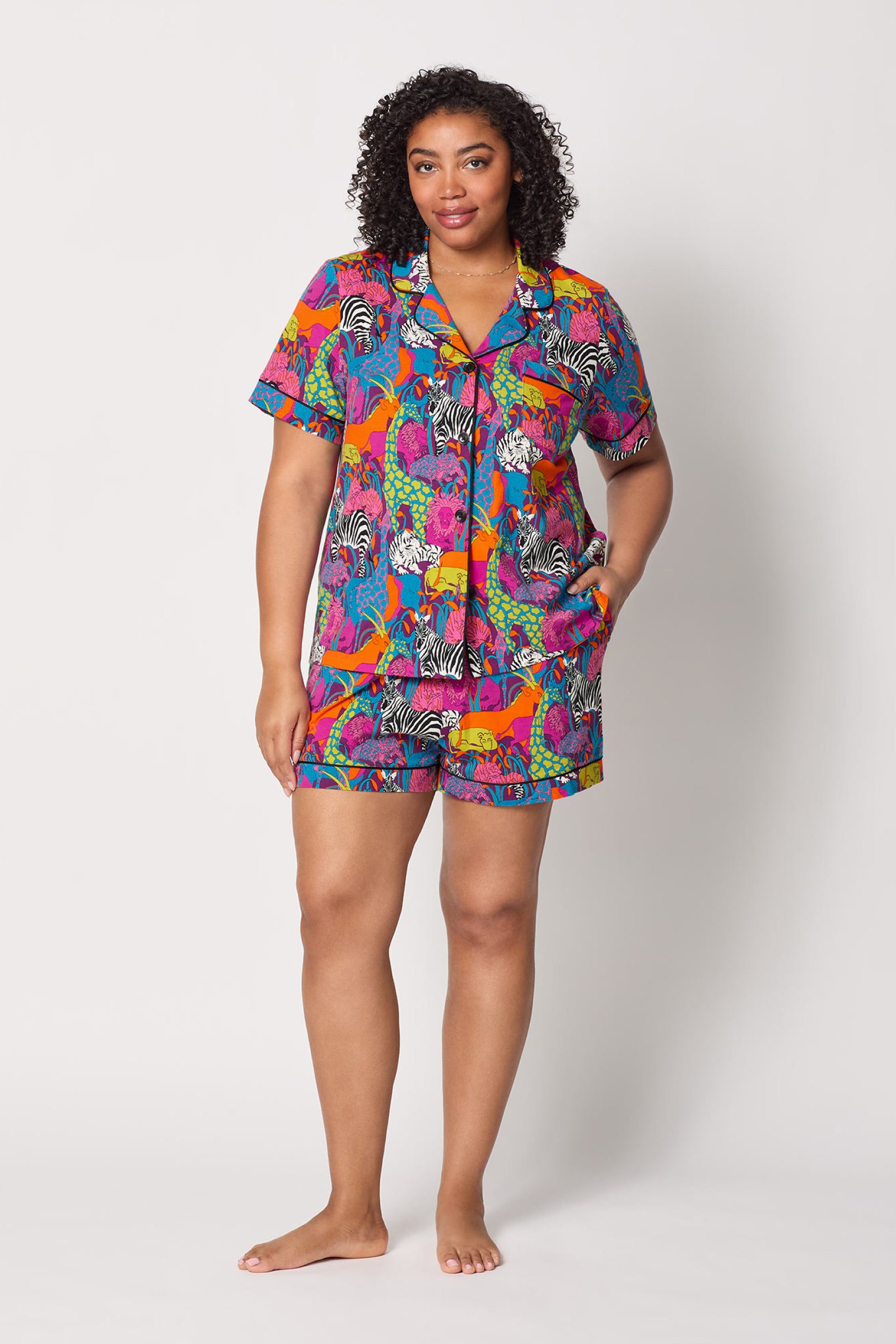 A woman wears the Shorty PJ Set - Jungle, a colorful outfit.