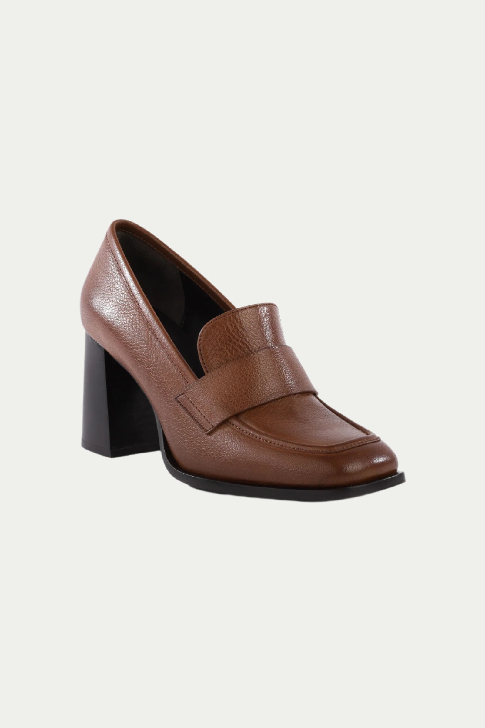 The Run The World Brown Leather Heeled Loafer features a chunky block heel, cushioned insole, wide front strap, and modern square toe—shown on a plain white background.