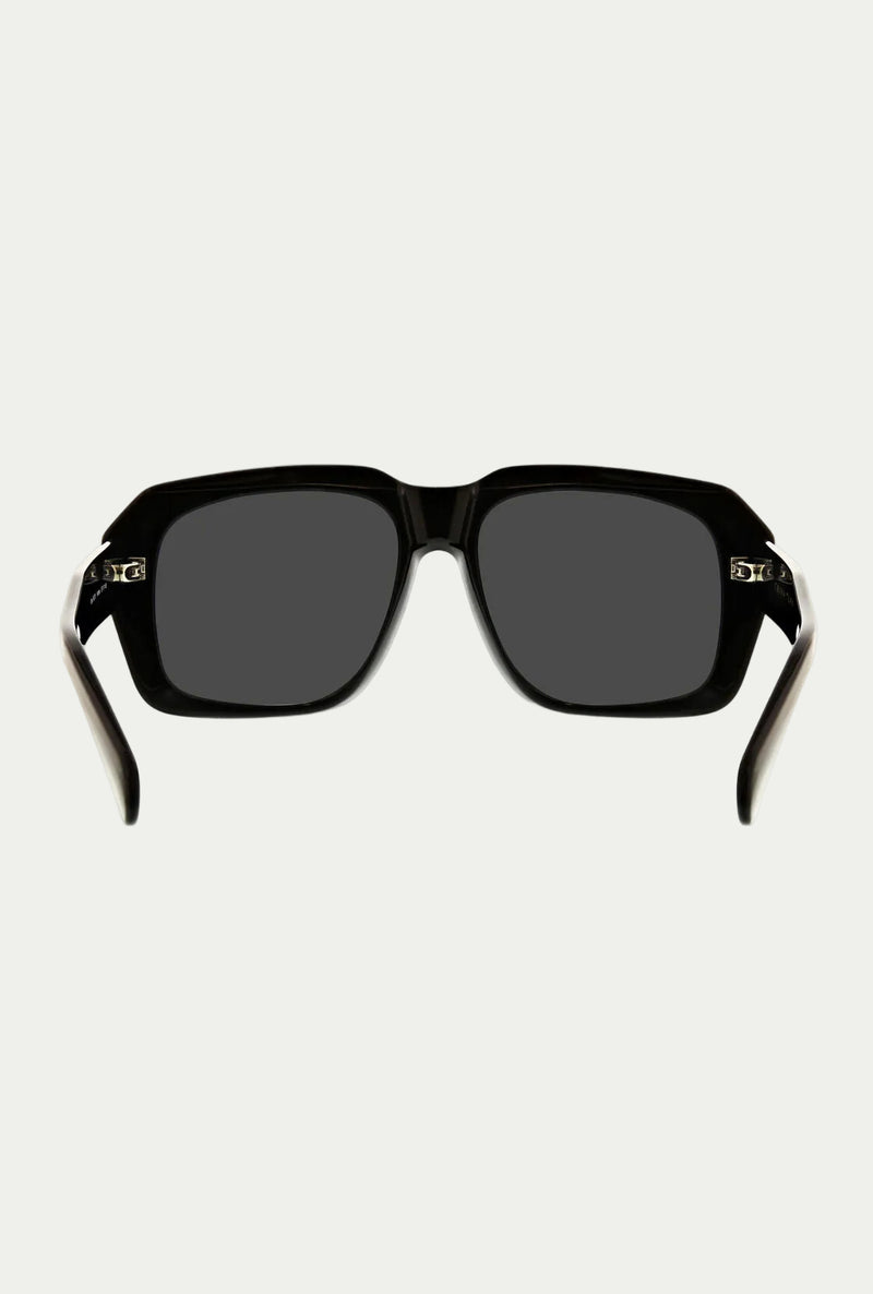 Front view of the Andros Sunglass featuring a bold black rectangular acetate frame, thick arms slightly open, and dark lenses offering 100% UVA/UVB protection, displayed on a white background.