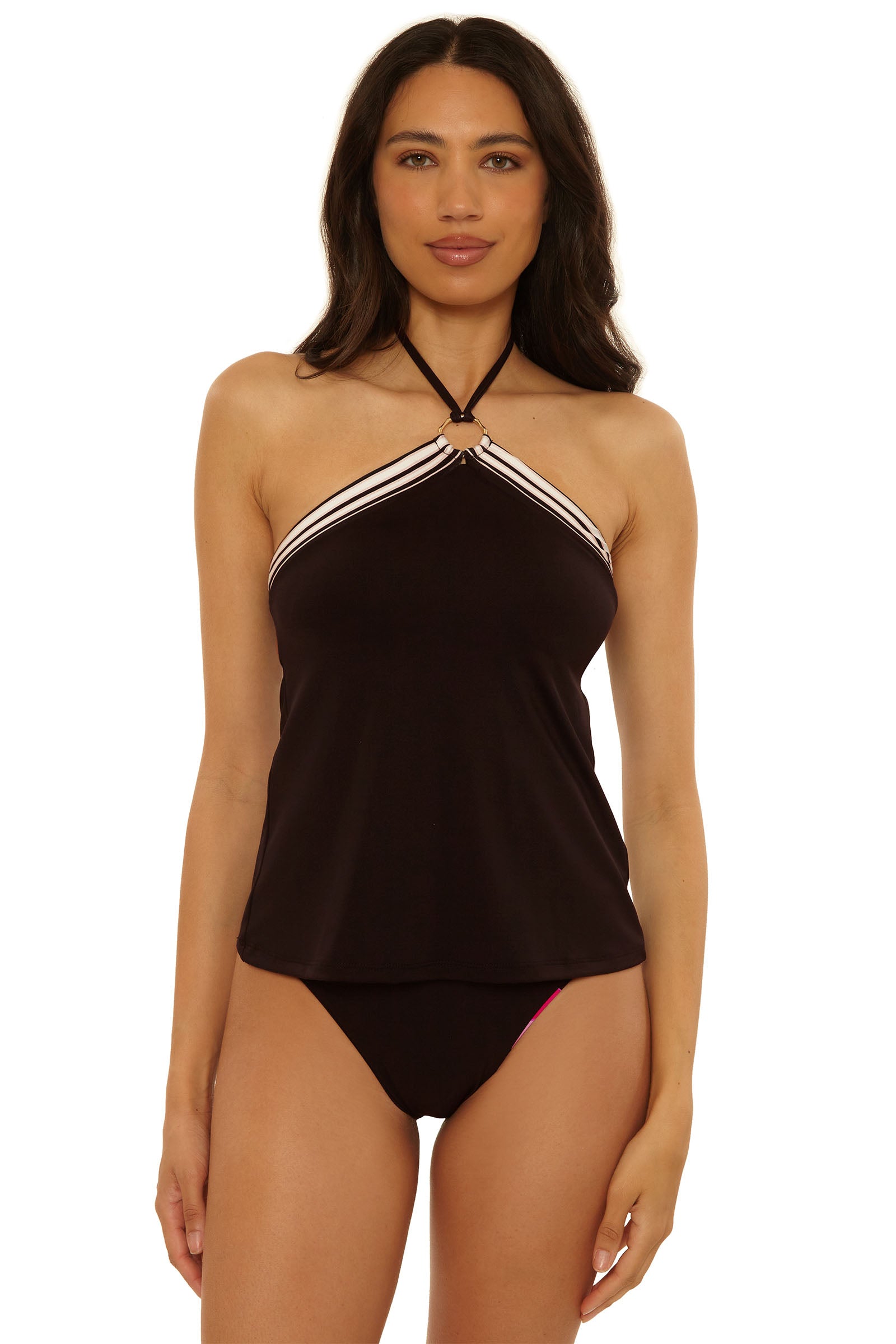 A woman stands facing forward against a plain white background, wearing the Reversible Tankini Swim Top – Bougainvillea paired with matching black bikini bottoms.