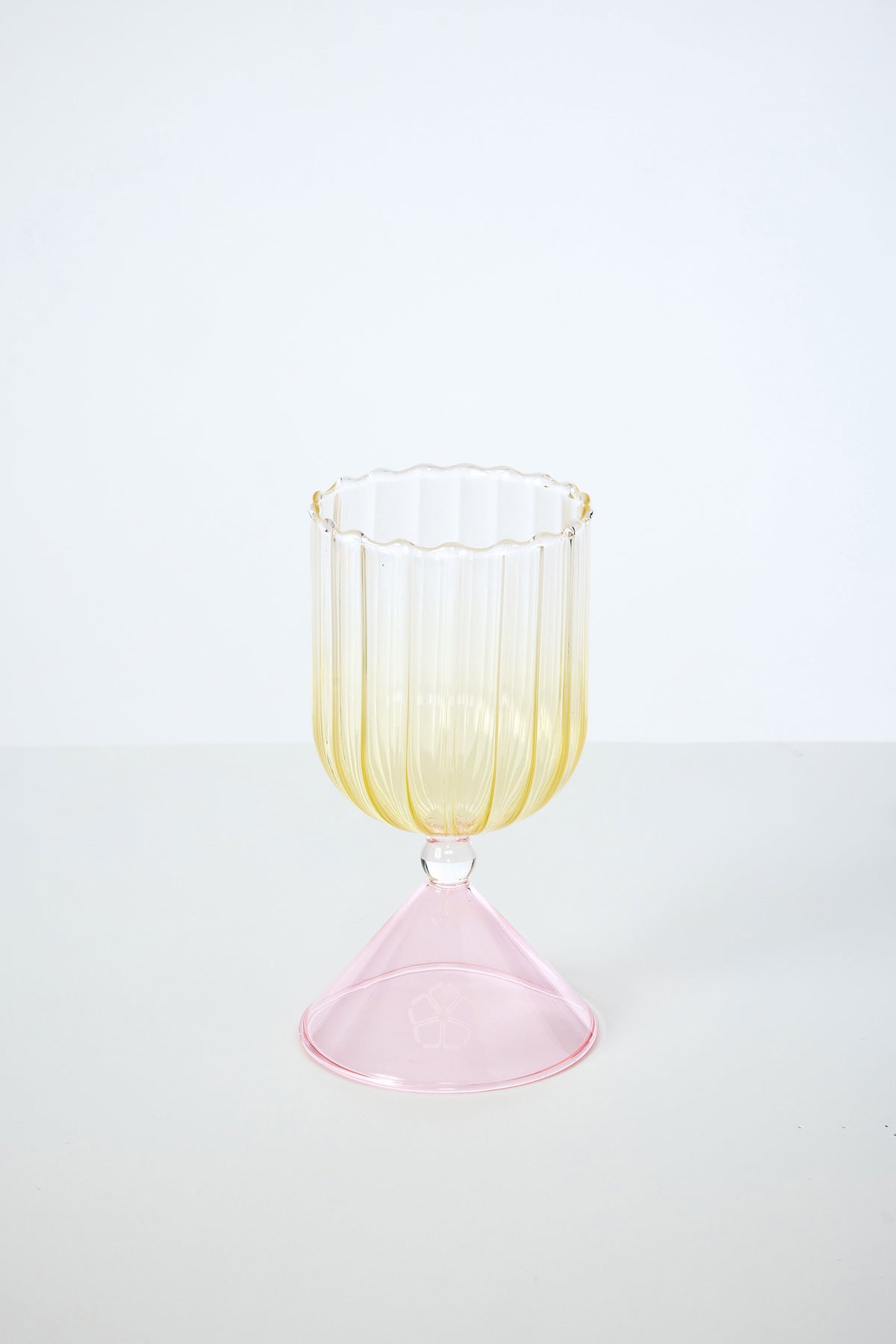 A Cocktail Glass from the set with Silicone Floret Mold, featuring a fluted yellow-tinted bowl and wide pink base, sits on a plain white surface against a light background.