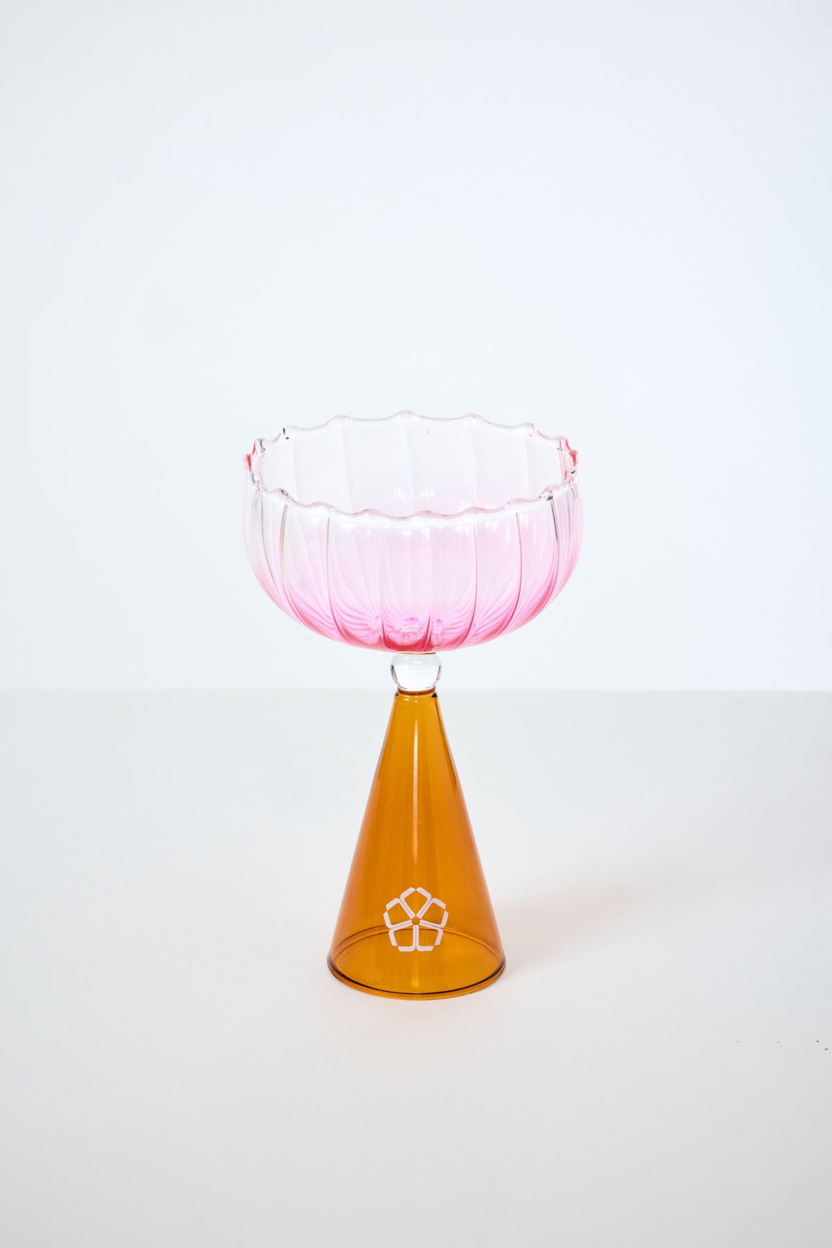 A Cocktail Glass with a fluted pink bowl and cone-shaped amber base, from the Cocktail Glass Set with Silicone Floret Mold, displayed against a plain white background.